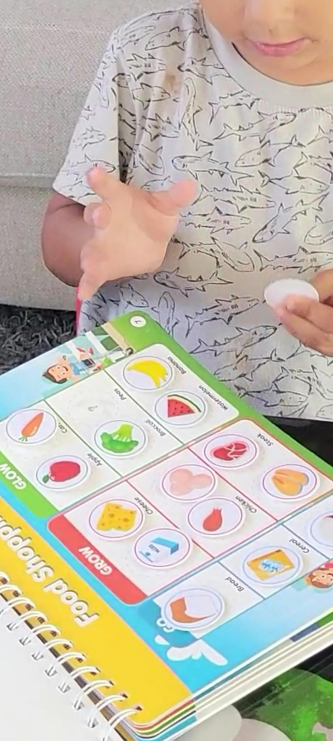 Child playing with a food shopping activity book