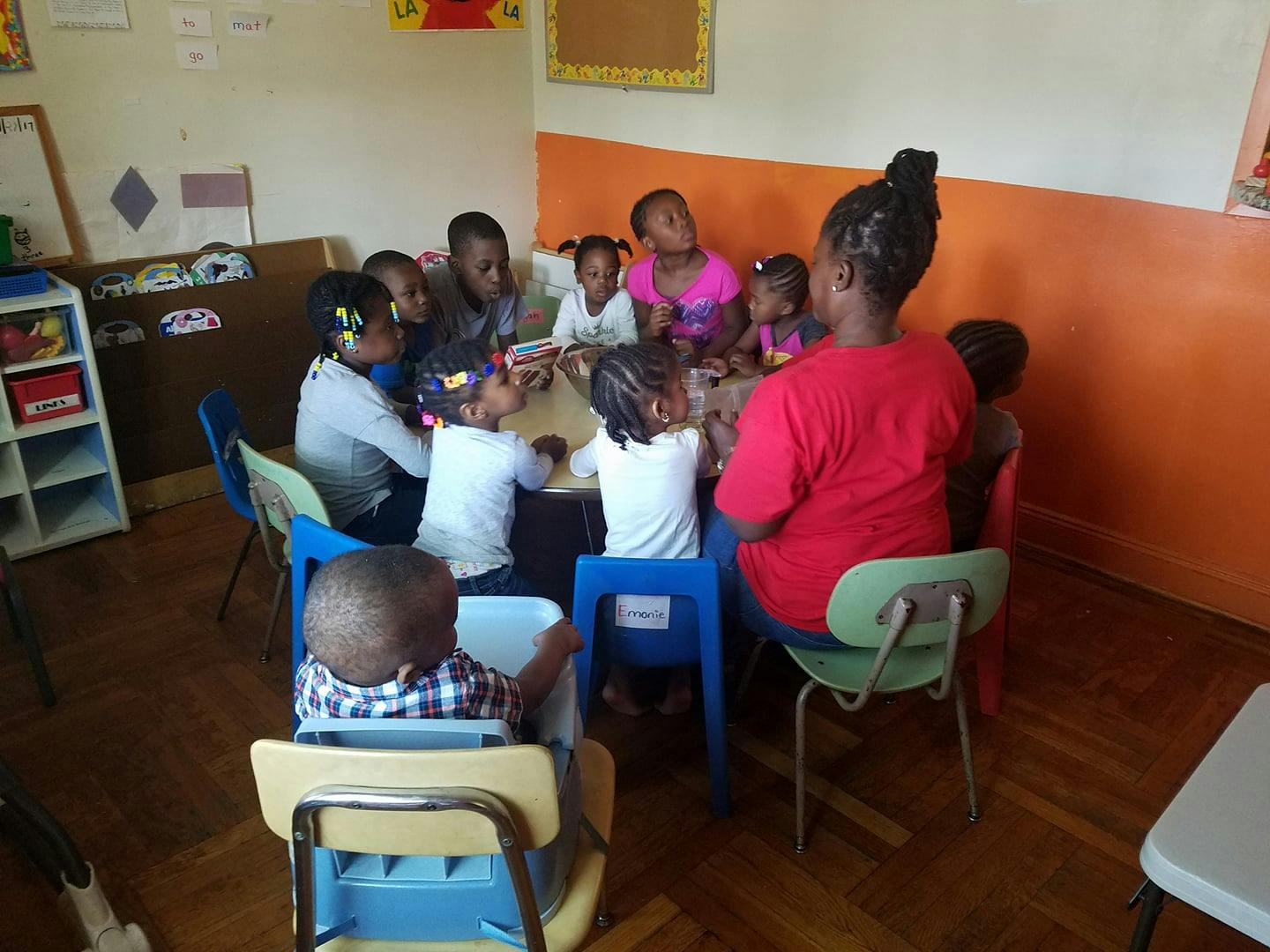 Adults and children sitting around a table in a classroom