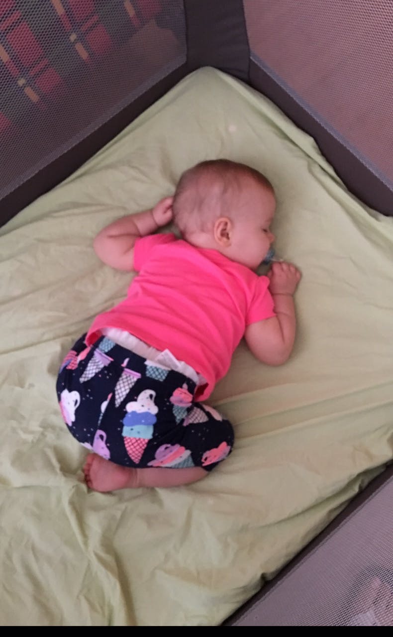 Child sleeping on a light green sheet