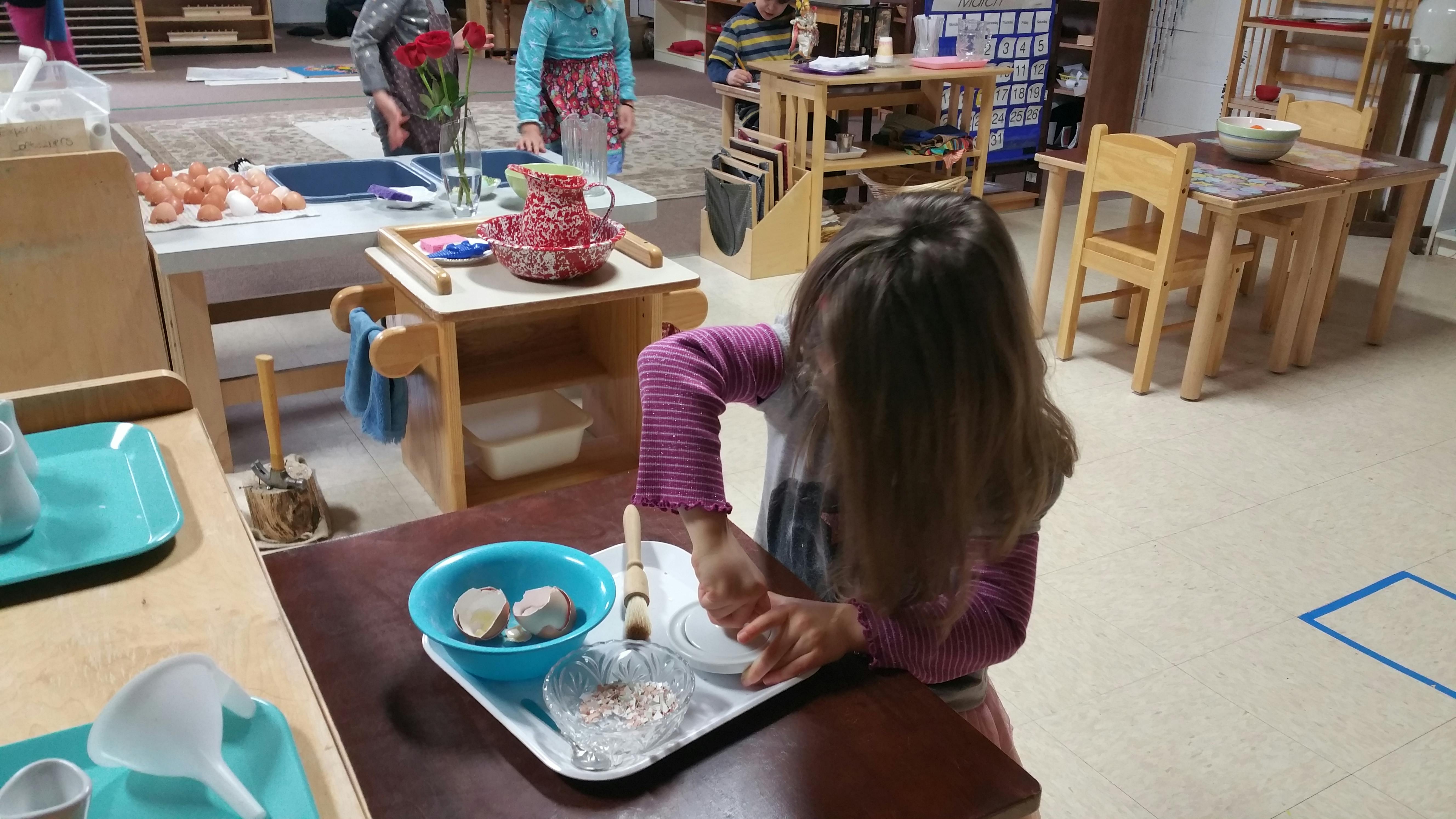 Child working with materials at a table in a classroom