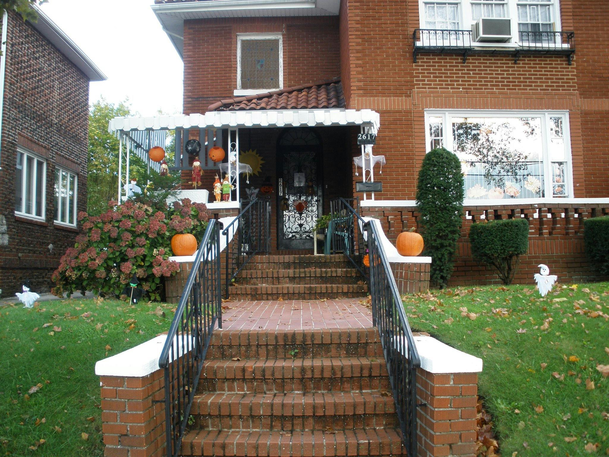 Brick house with pumpkins and Halloween decorations on the porch