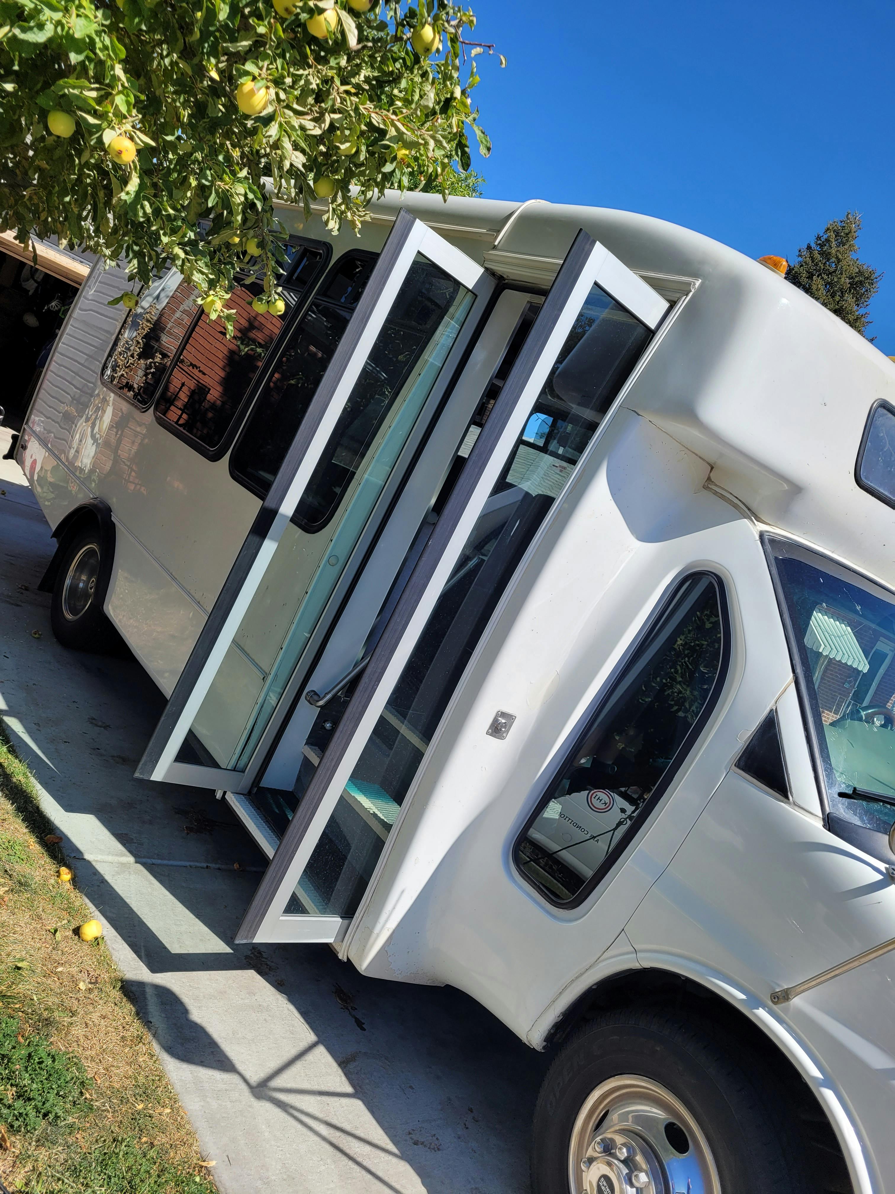 White shuttle bus with open accordion doors