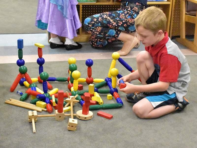 Child playing with colorful building blocks on the floor