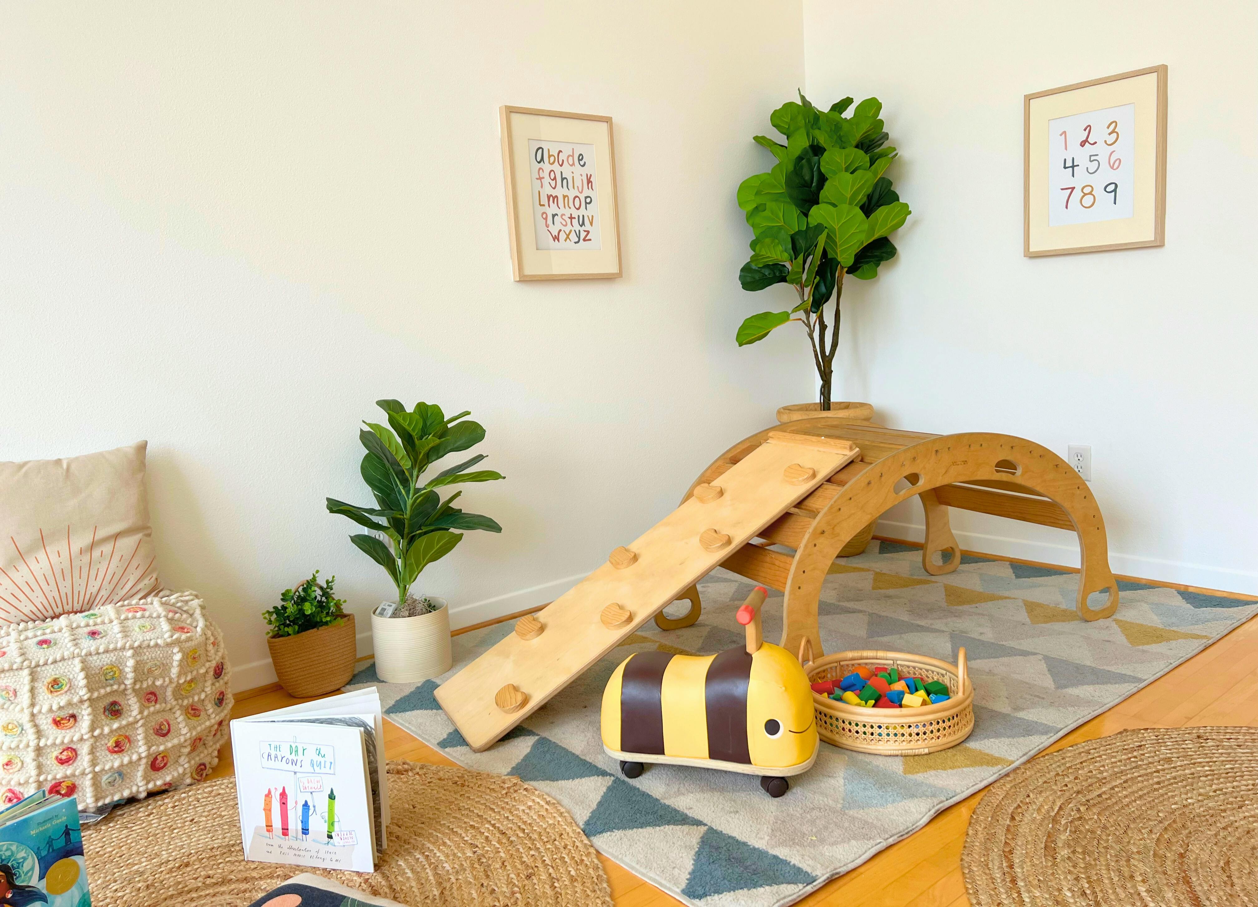 Indoor play area with wooden slide, climbing arch, and bee-shaped ride-on toy