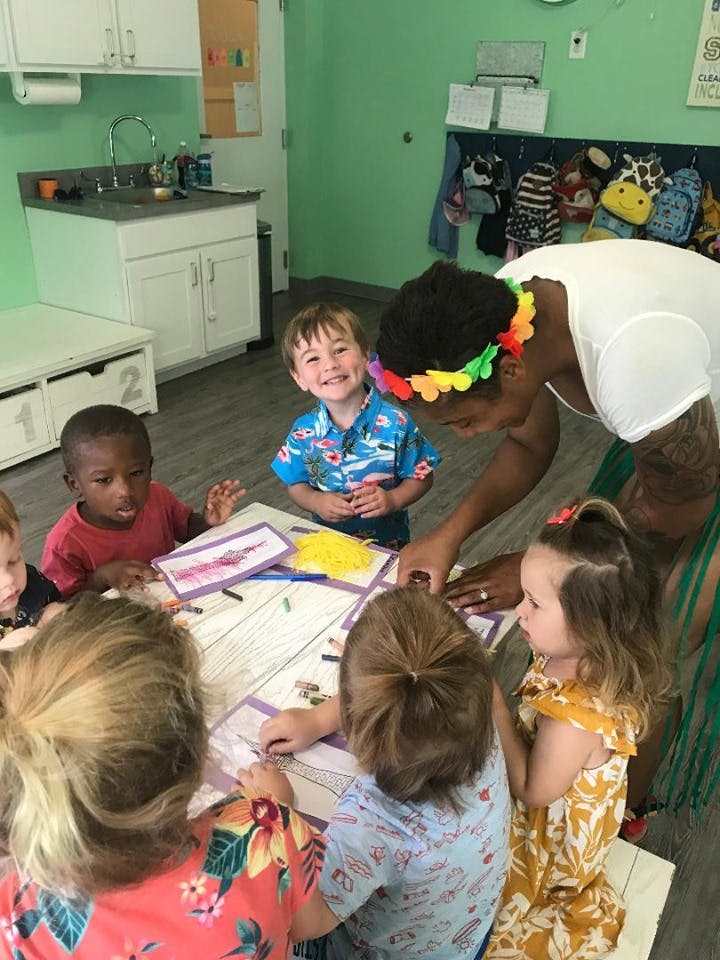 Adult and children gathered around a table with art supplies