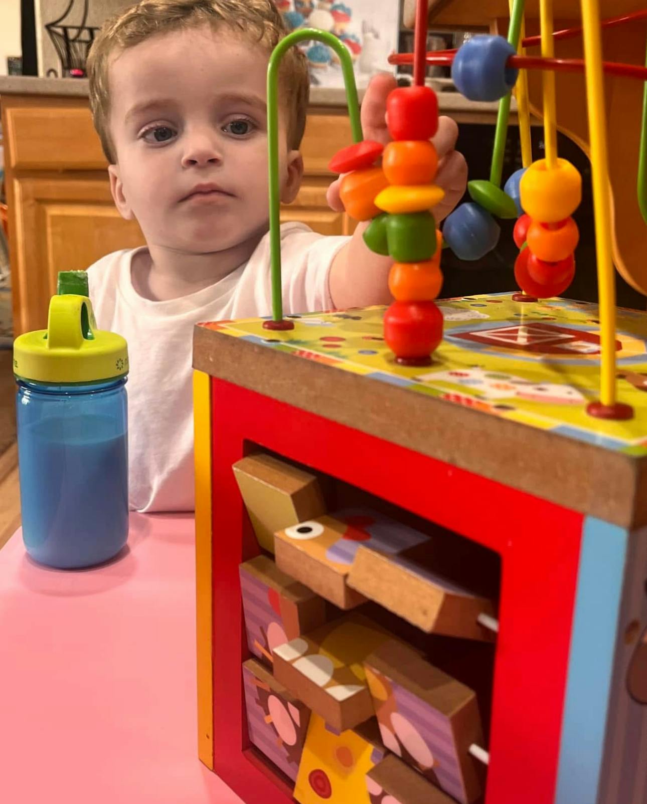 Child playing with a wooden activity cube