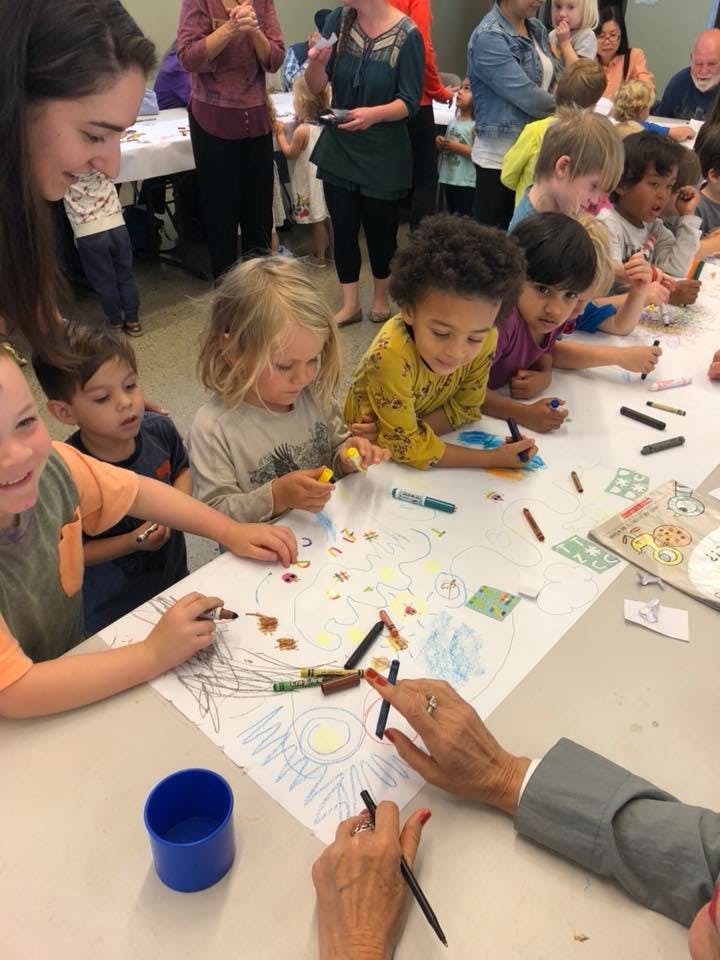 Children and adults drawing together at a table