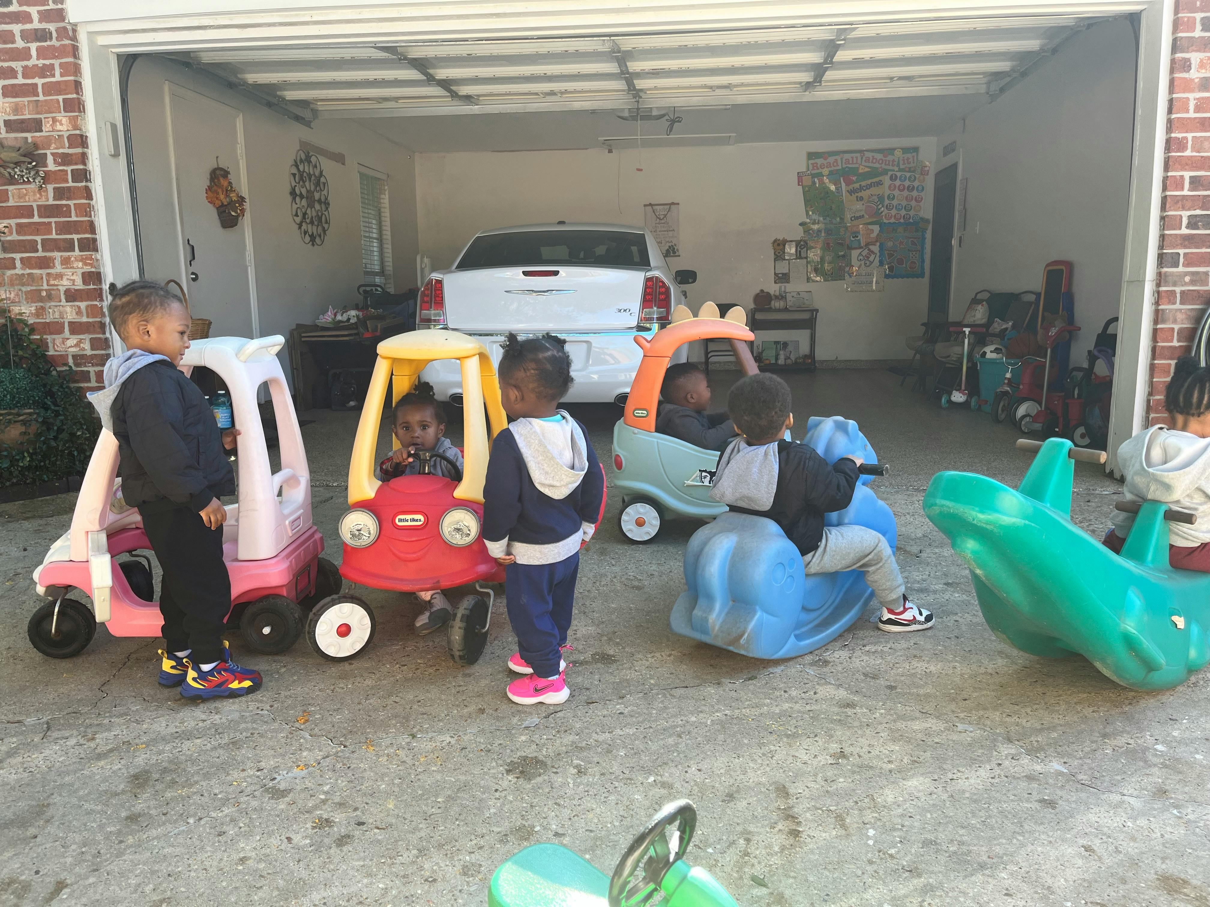 Children playing with ride-on toys in a garage