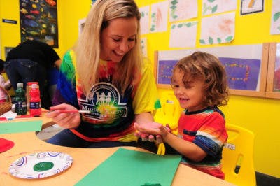 Adult and child painting in a classroom