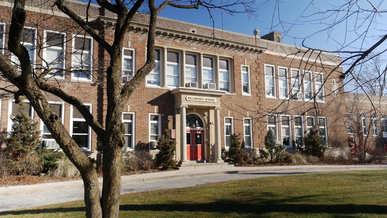 Brick building with many windows and a prominent entrance