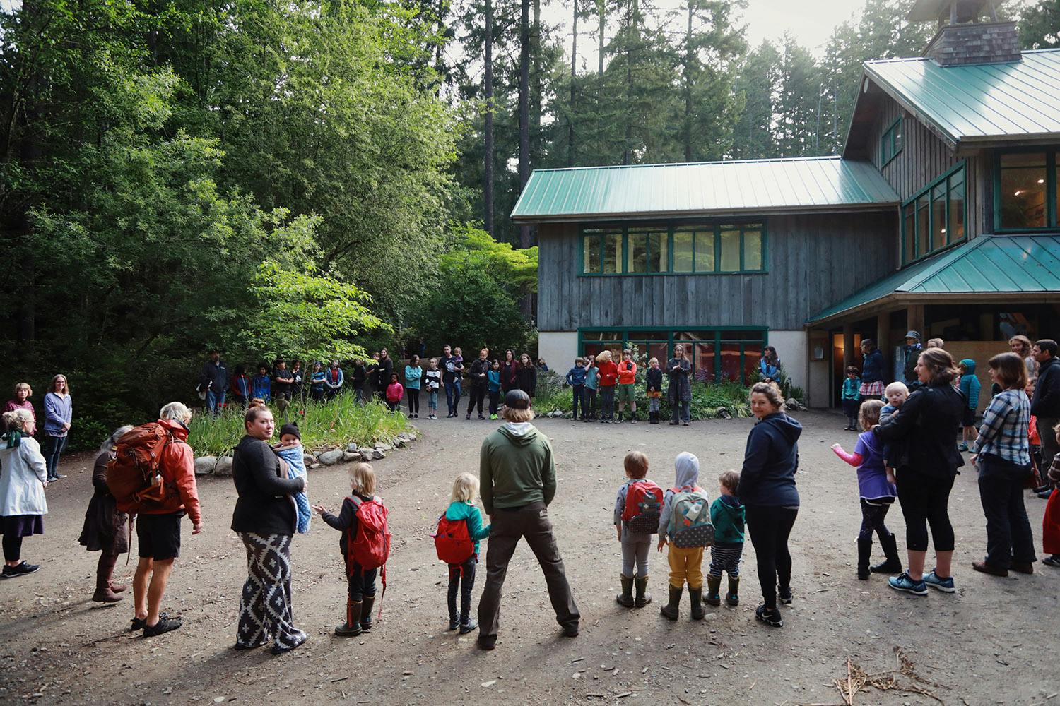 People and children gathered outdoors in front of a building