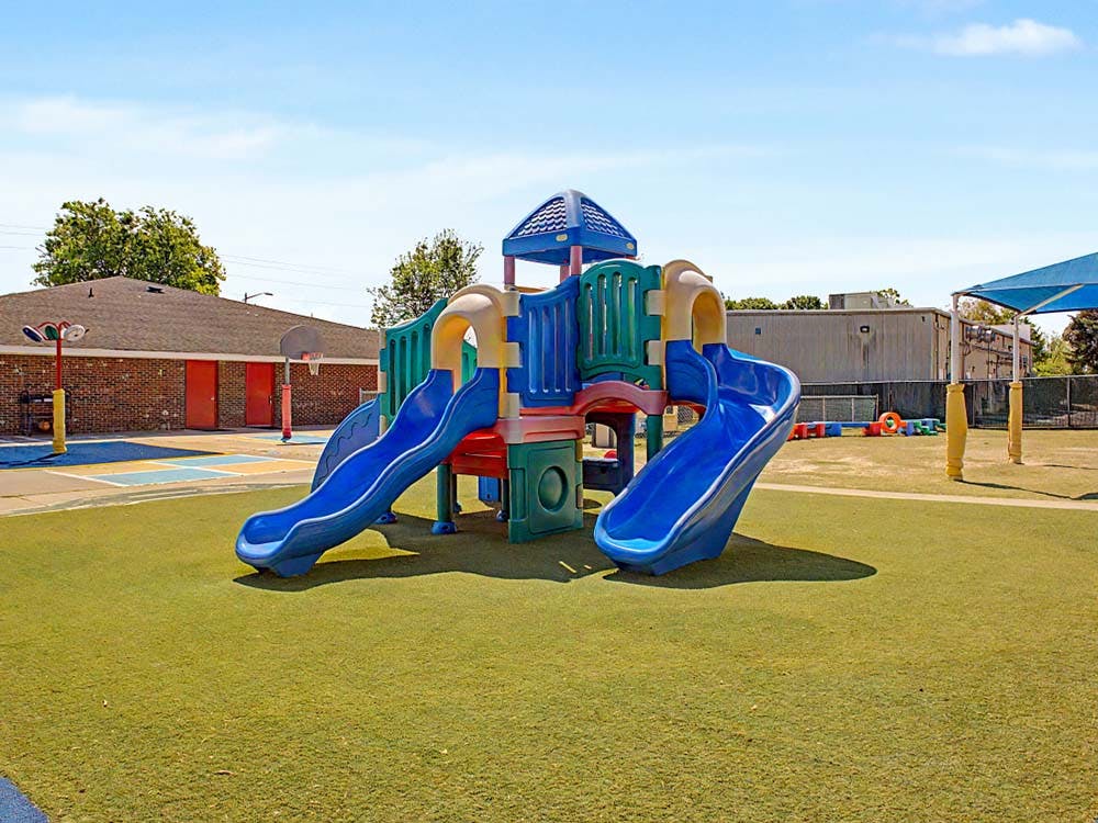 Playground with climbing structure and slides on artificial turf