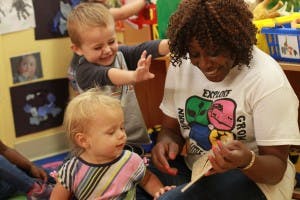 Adult and two children interacting in a classroom