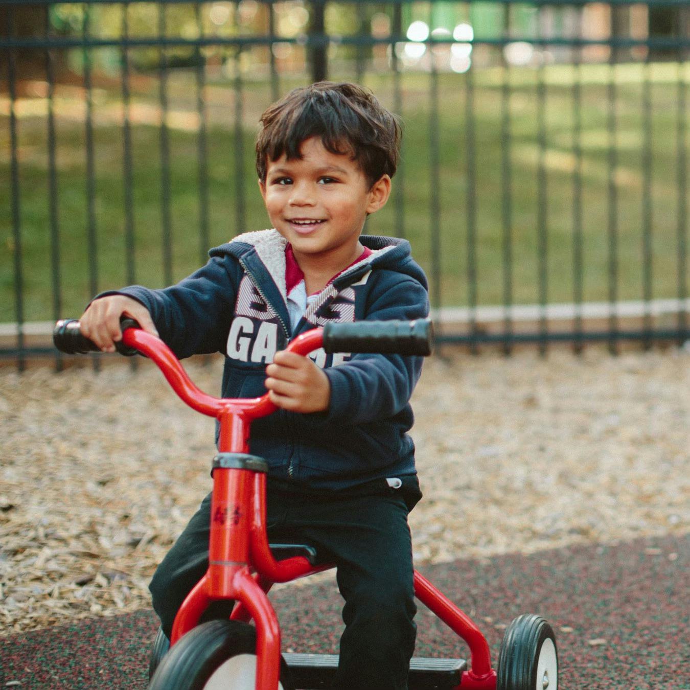 Child on a red tricycle