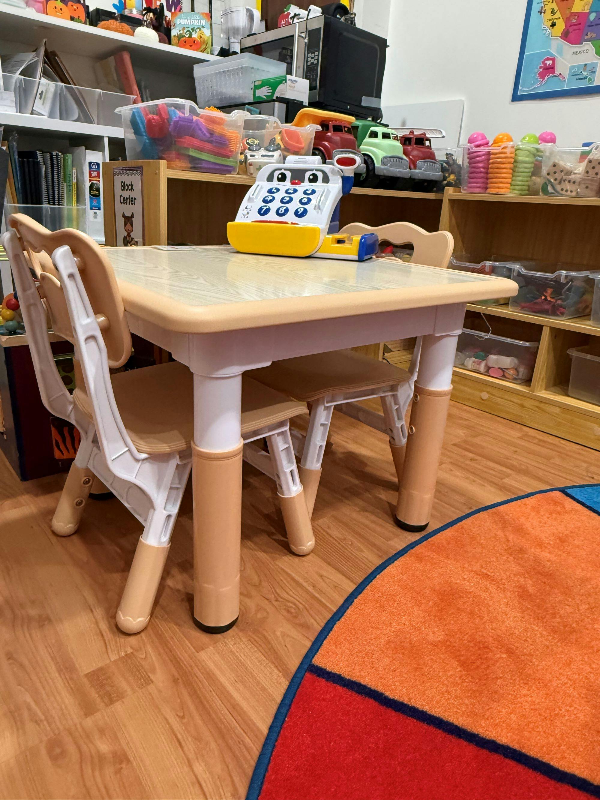 Toy cash register on a small table with chairs in a classroom