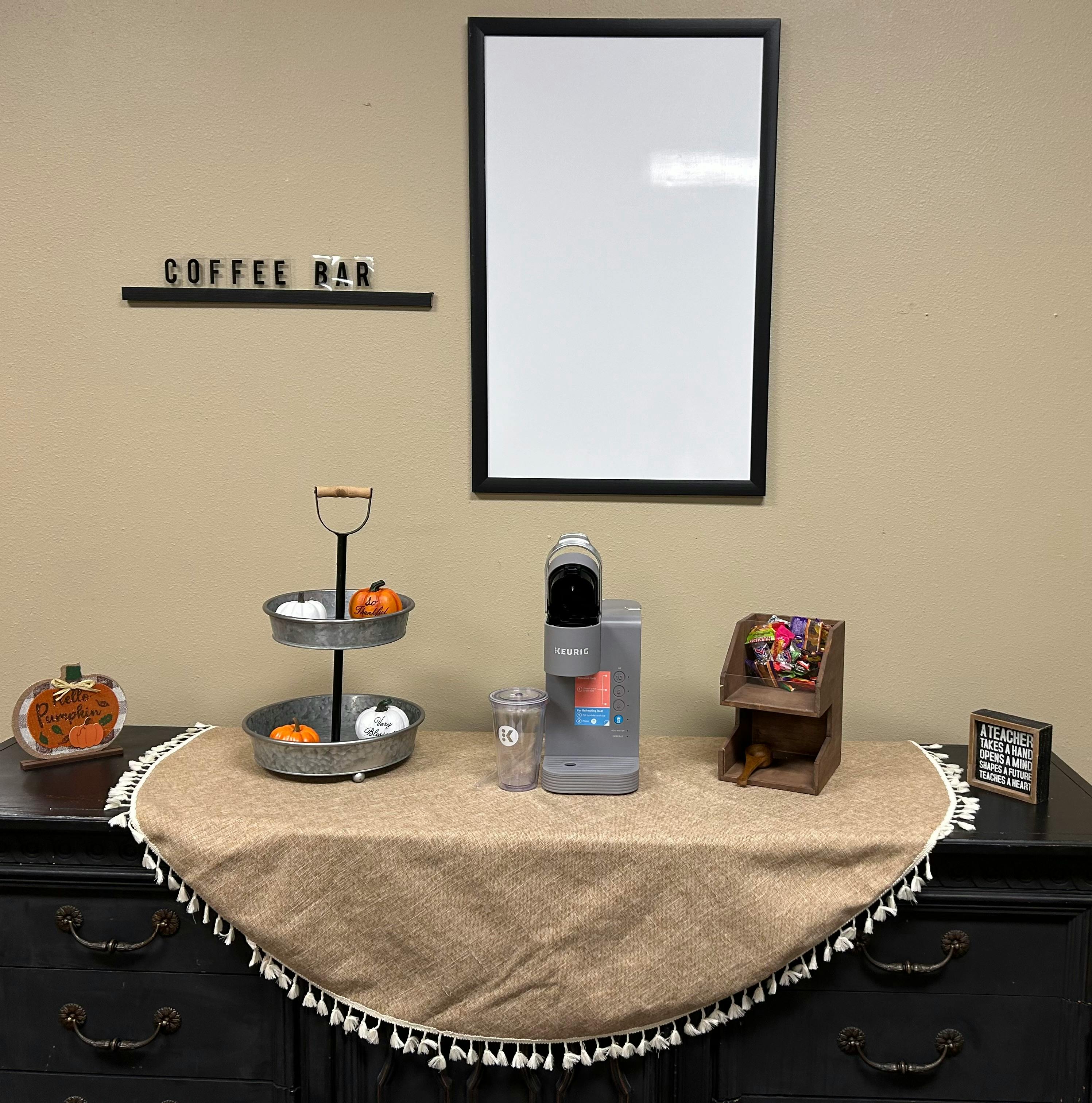 Coffee bar with a coffee maker, tiered tray, and a sign that reads "COFFEE BAR"