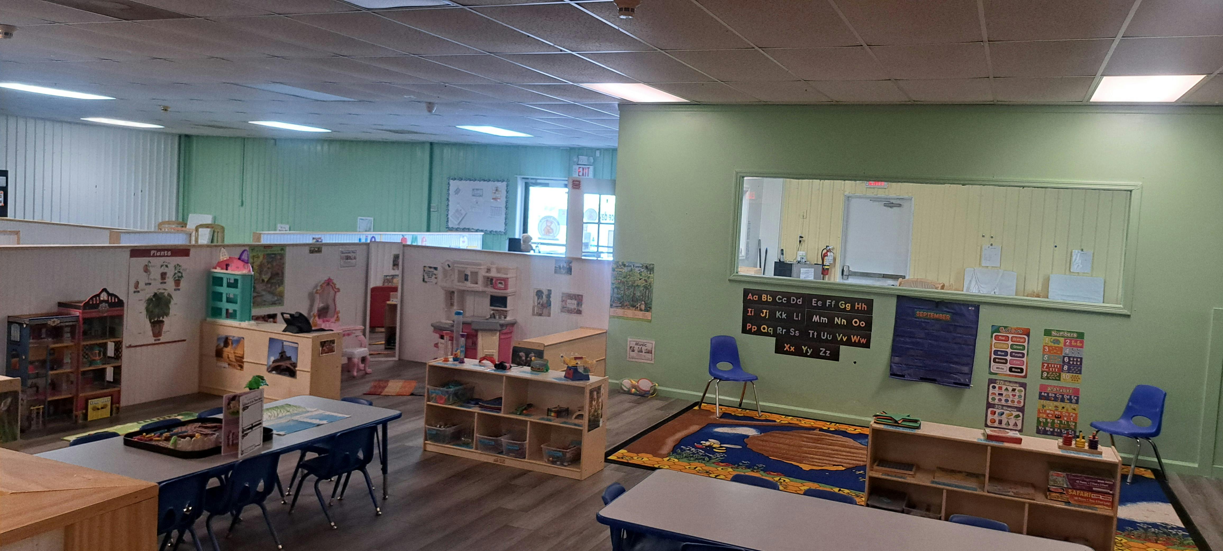 Empty classroom with tables, chairs, and cubbies