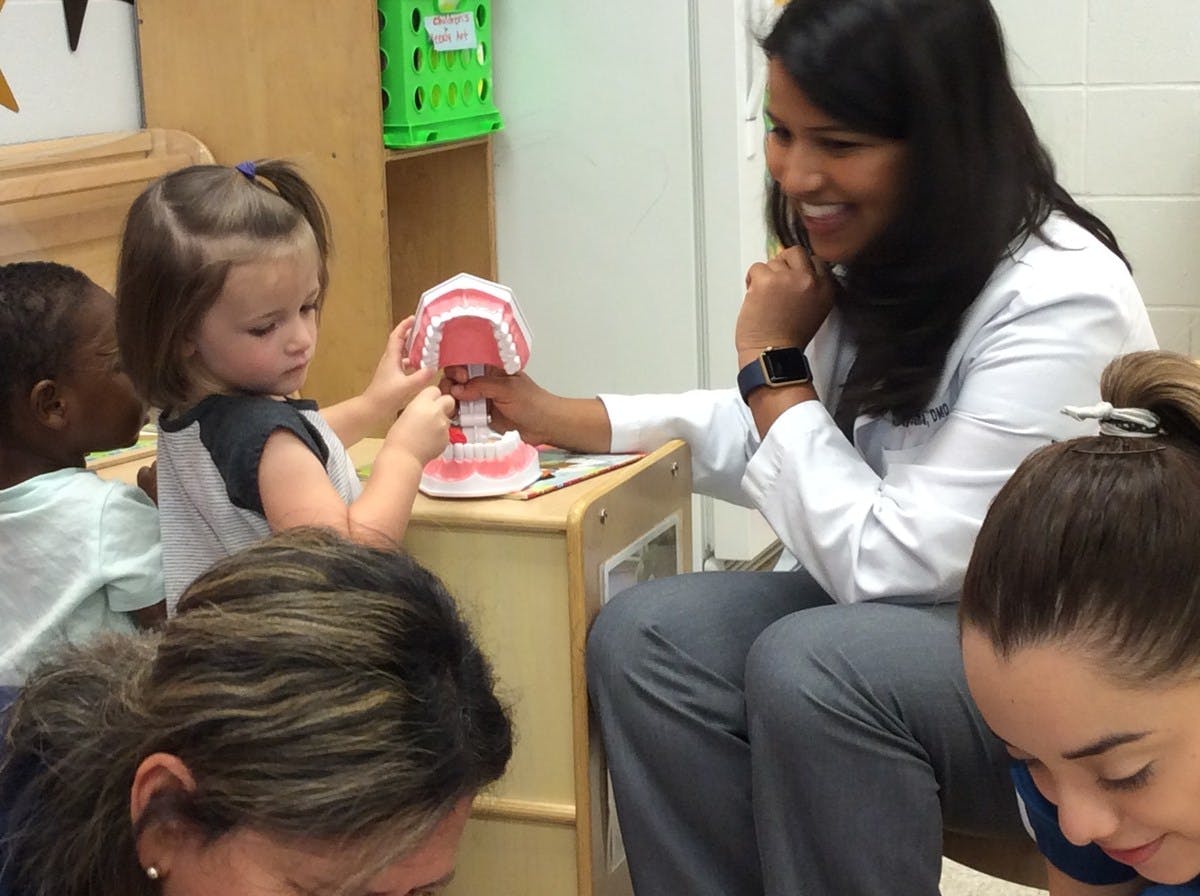 Adult and child interacting with a dental model