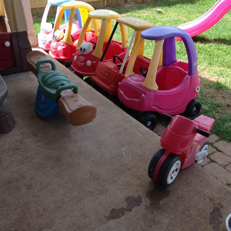 Toy cars, scooter, and seesaw on a patio