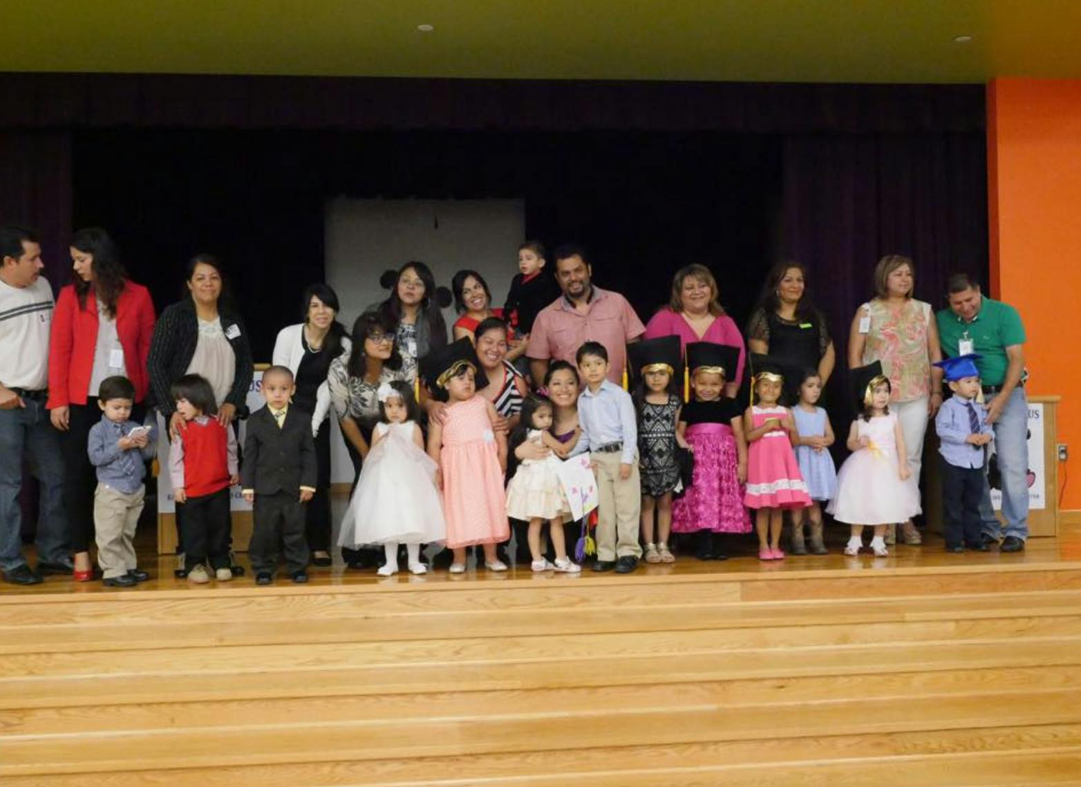 Group of adults and children standing on a stage