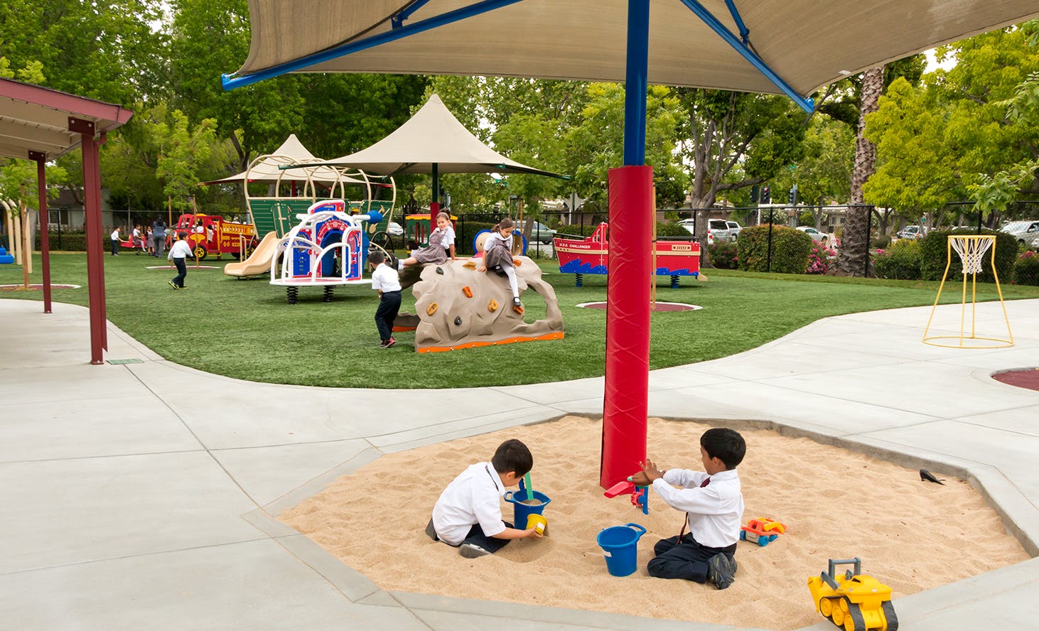Children playing in a sandbox and on playground equipment