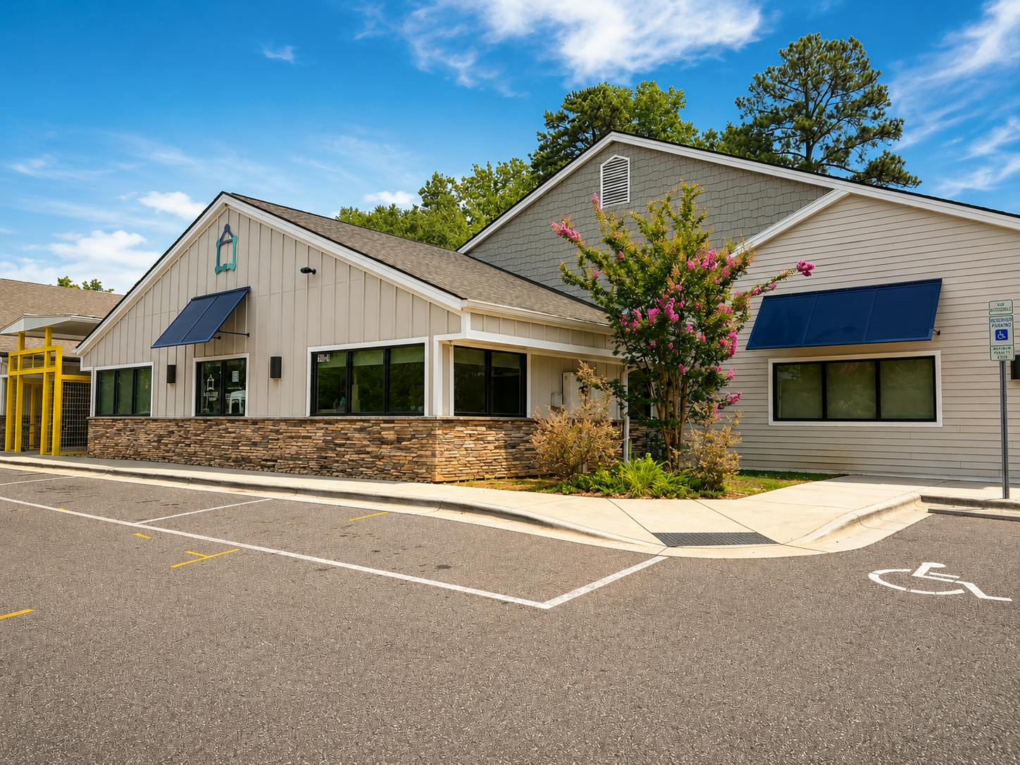 Exterior of a commercial building with a parking lot and accessible parking sign