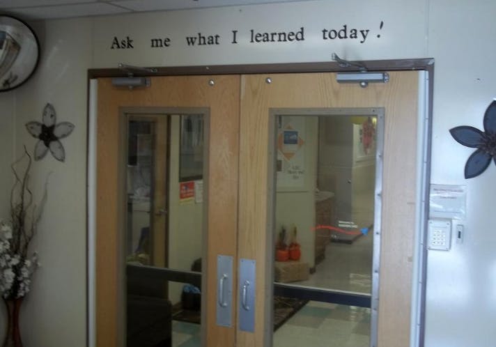 Double doors with text above them that reads "Ask me what I learned today!"