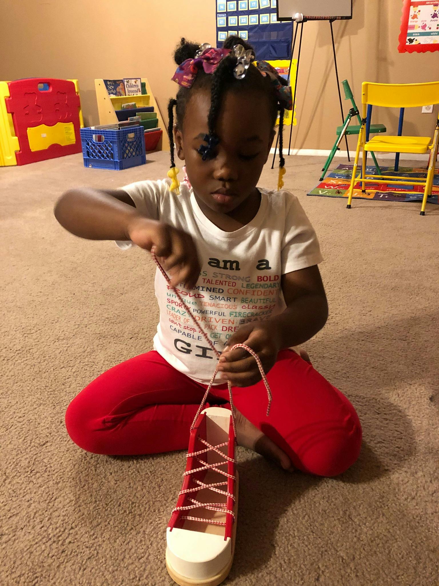 Child lacing a practice shoe