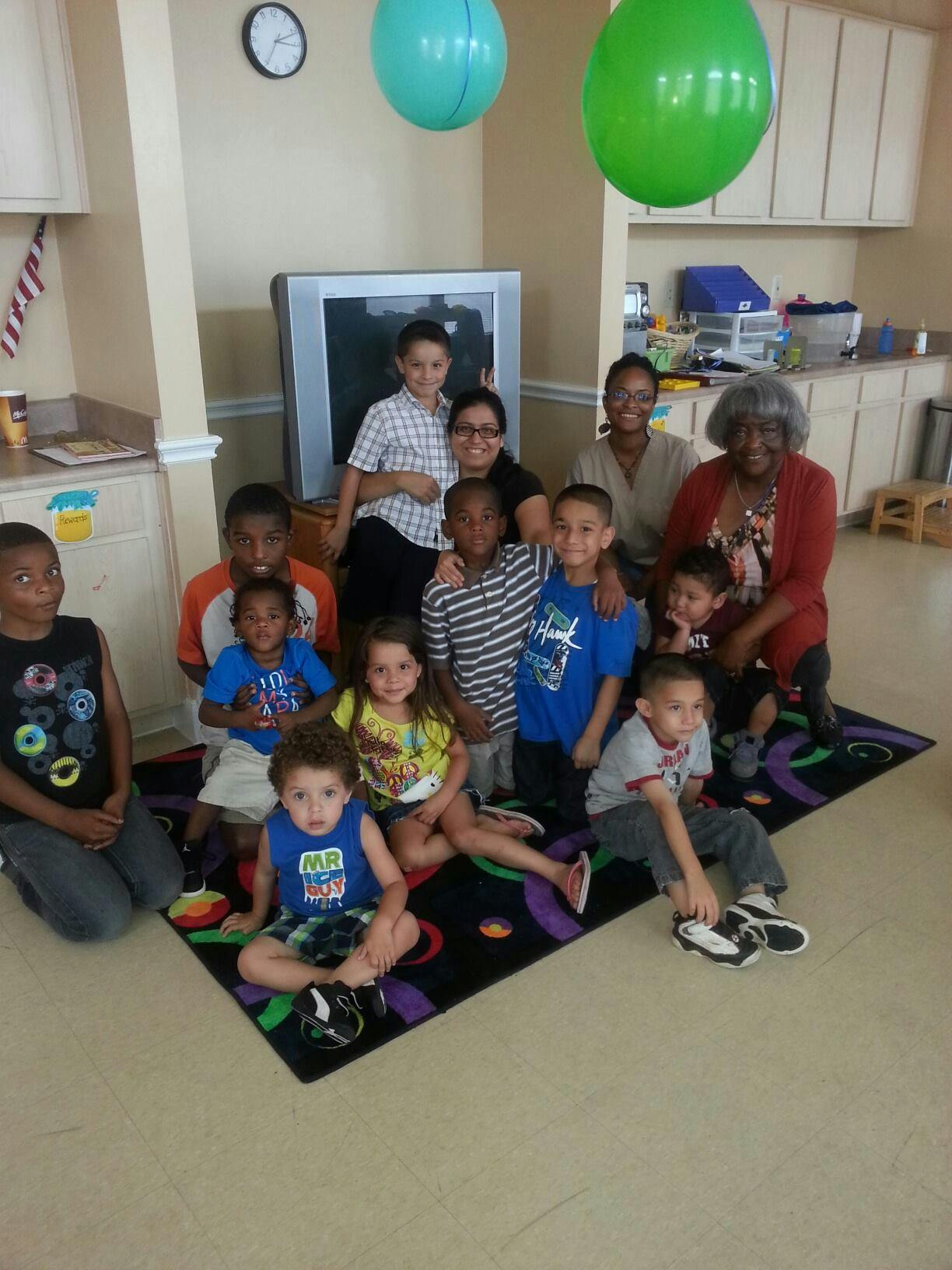 Group of adults and children posing for a photo indoors