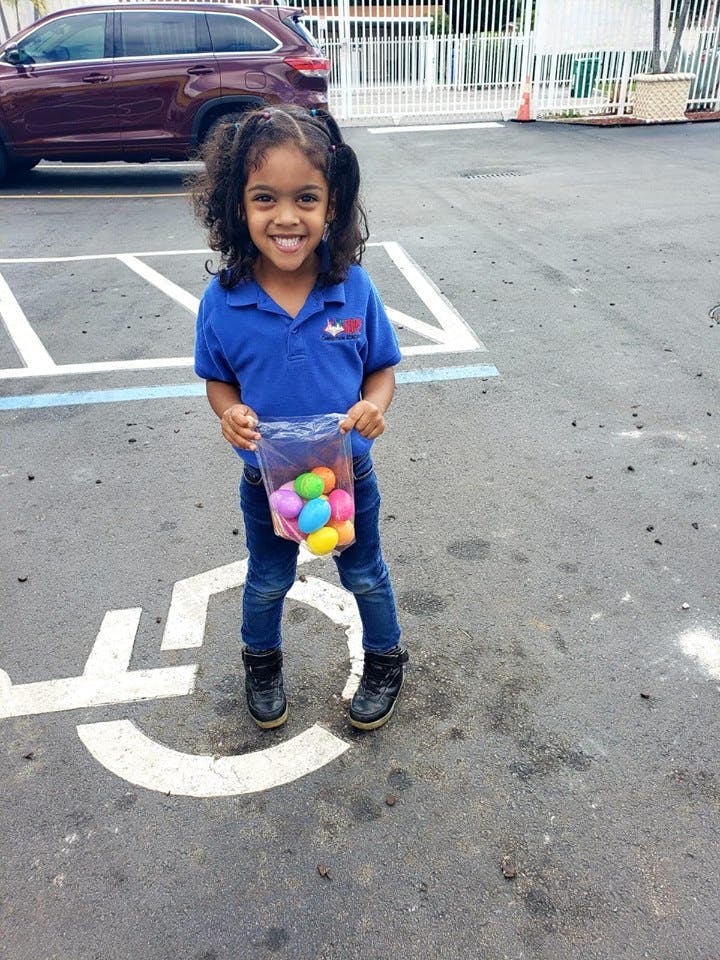 Child holding a bag of colorful plastic eggs