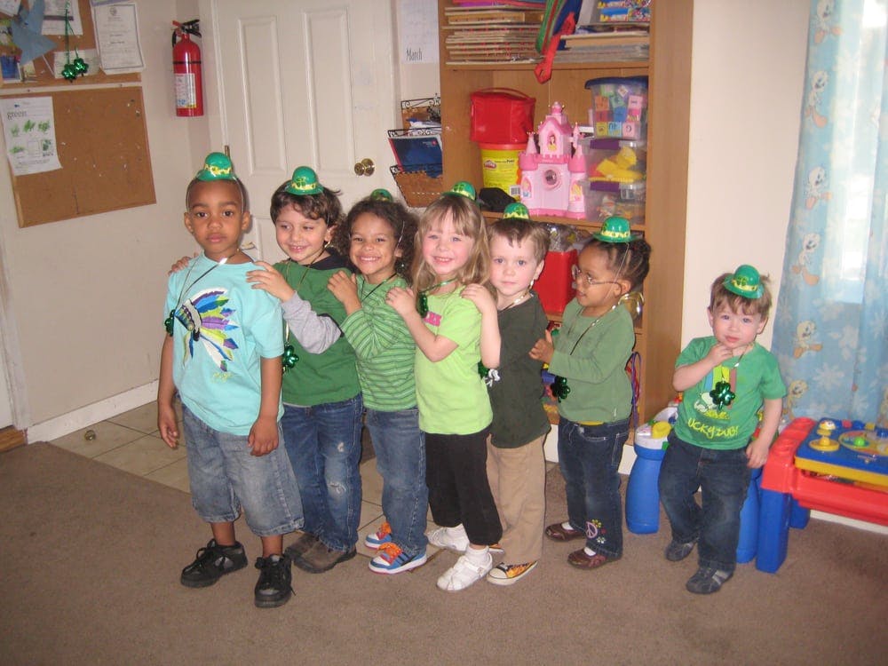 Group of children wearing green hats standing in a line