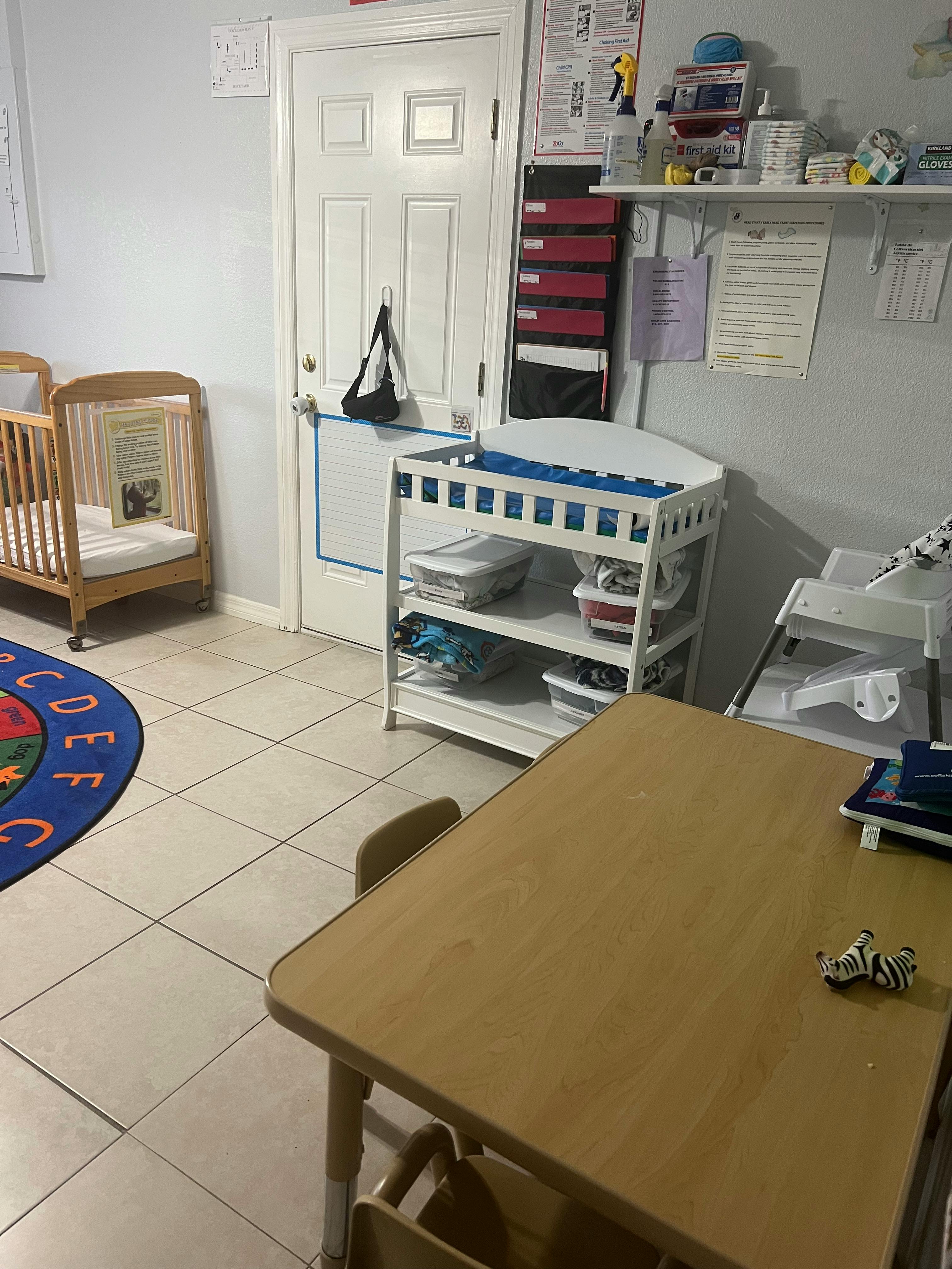 Nursery room with crib, changing table, and small table with chairs