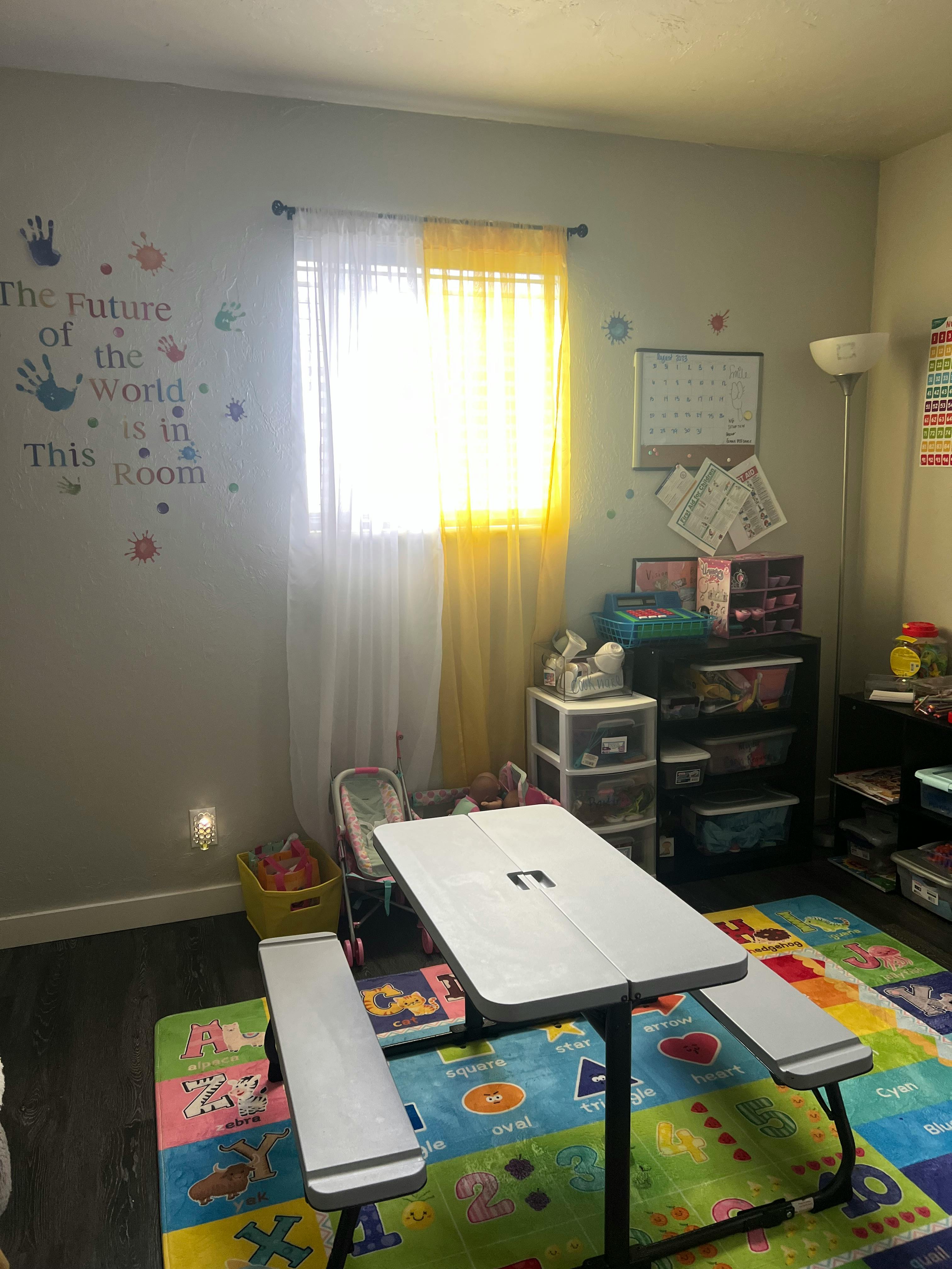 Children's room with a small table and benches on a colorful playmat