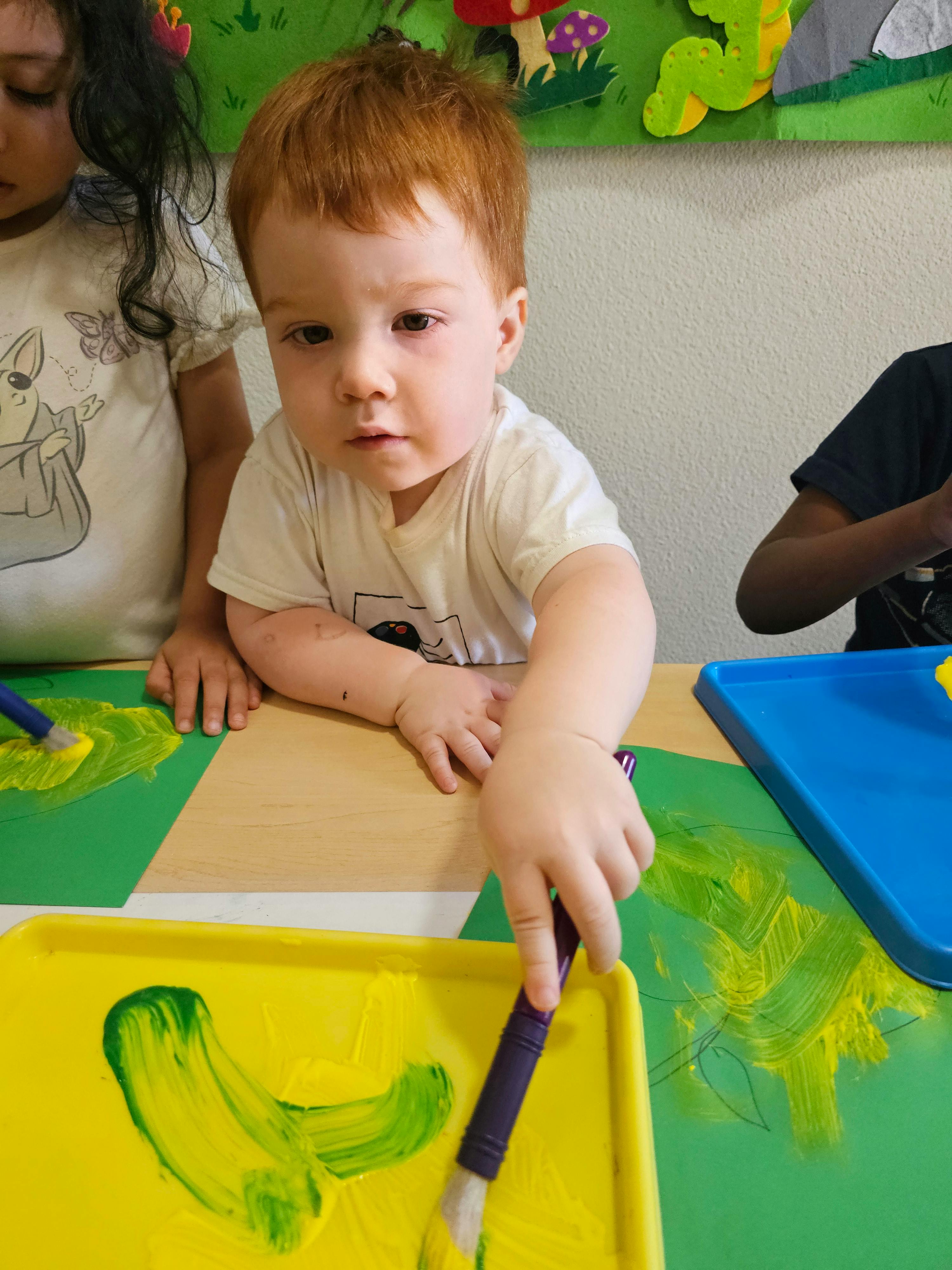 Child painting on paper at a table