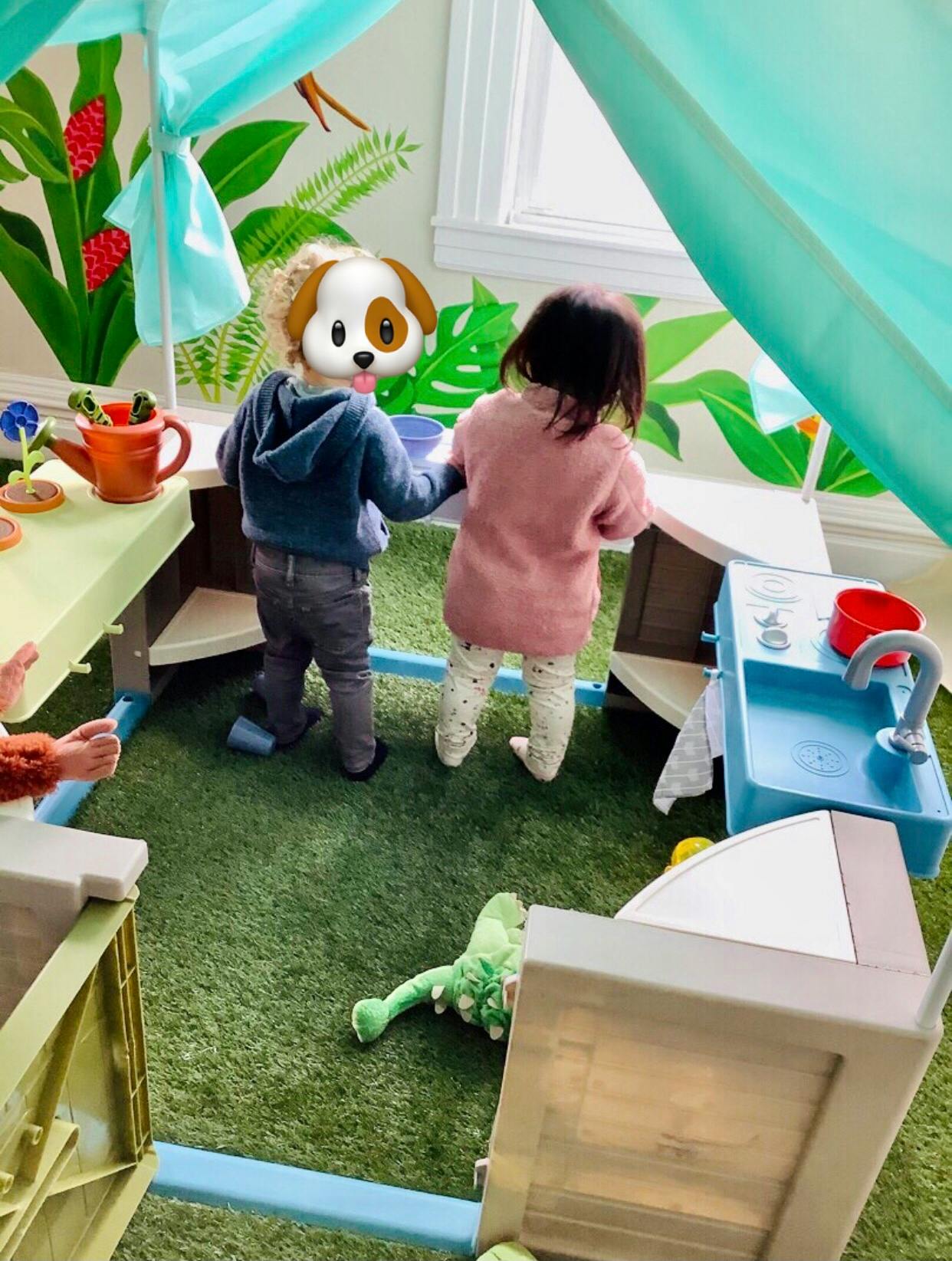 Two children playing with a toy kitchen set