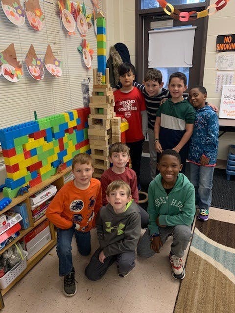 Group of children posing in a classroom with building blocks
