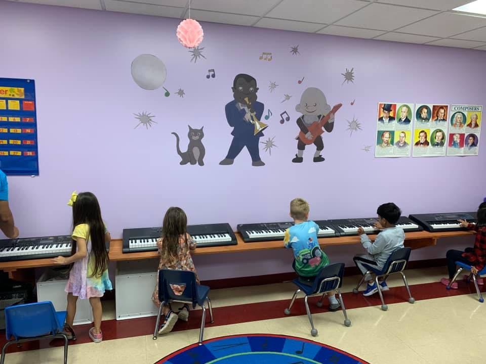 Children learning to play keyboards in a classroom