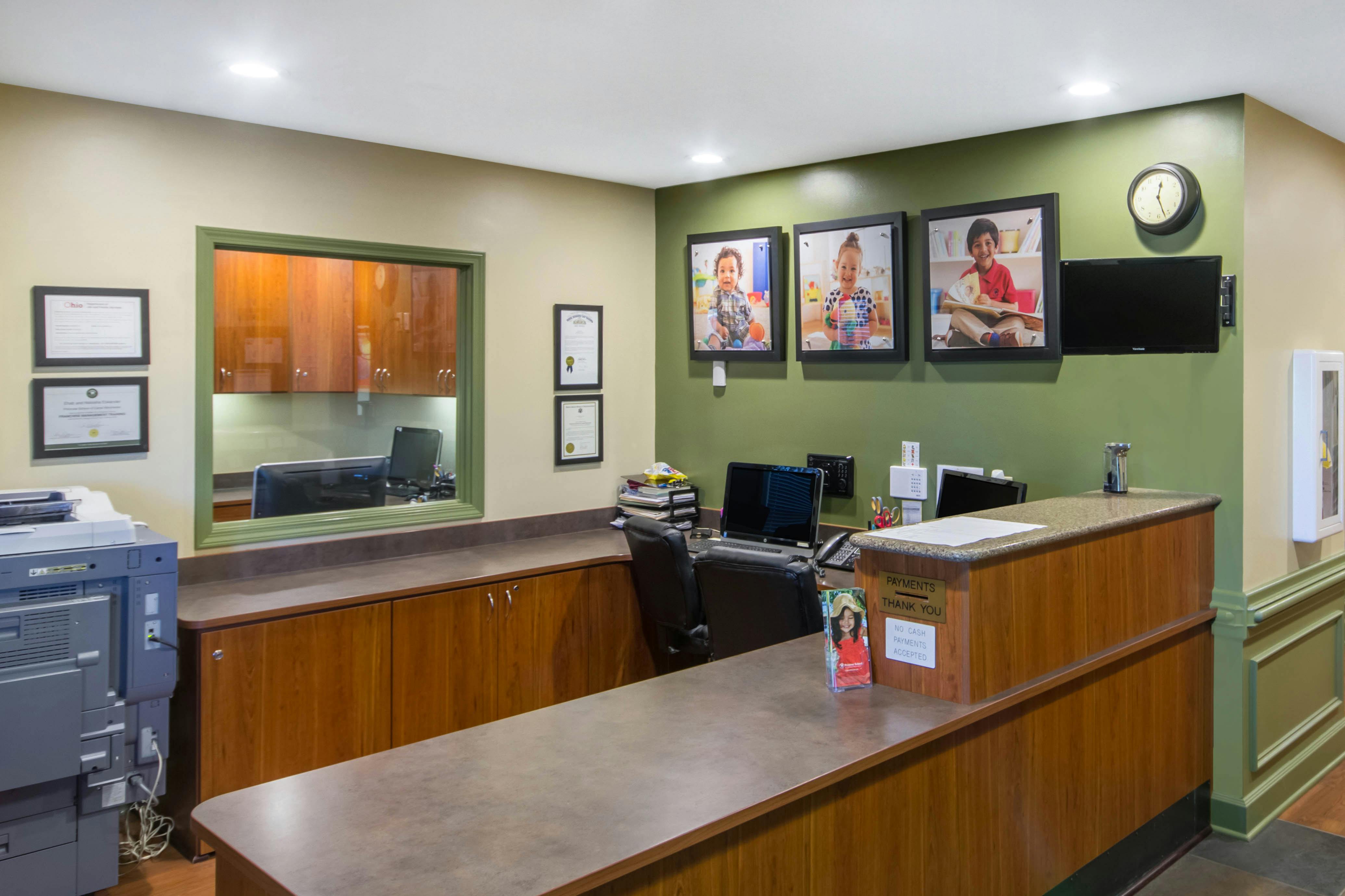 Reception desk with office equipment and framed photos of children