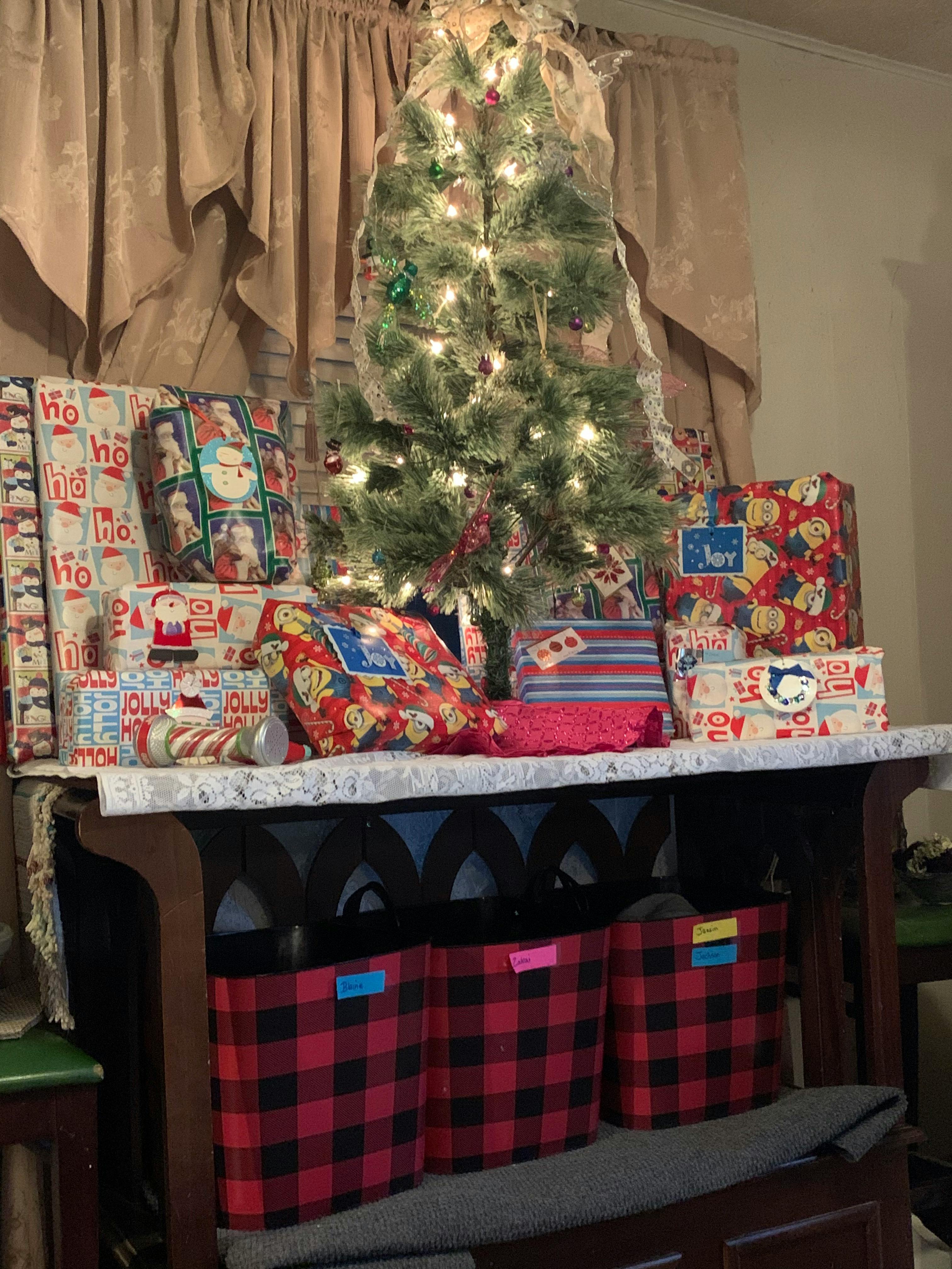 Christmas tree with lights surrounded by wrapped presents