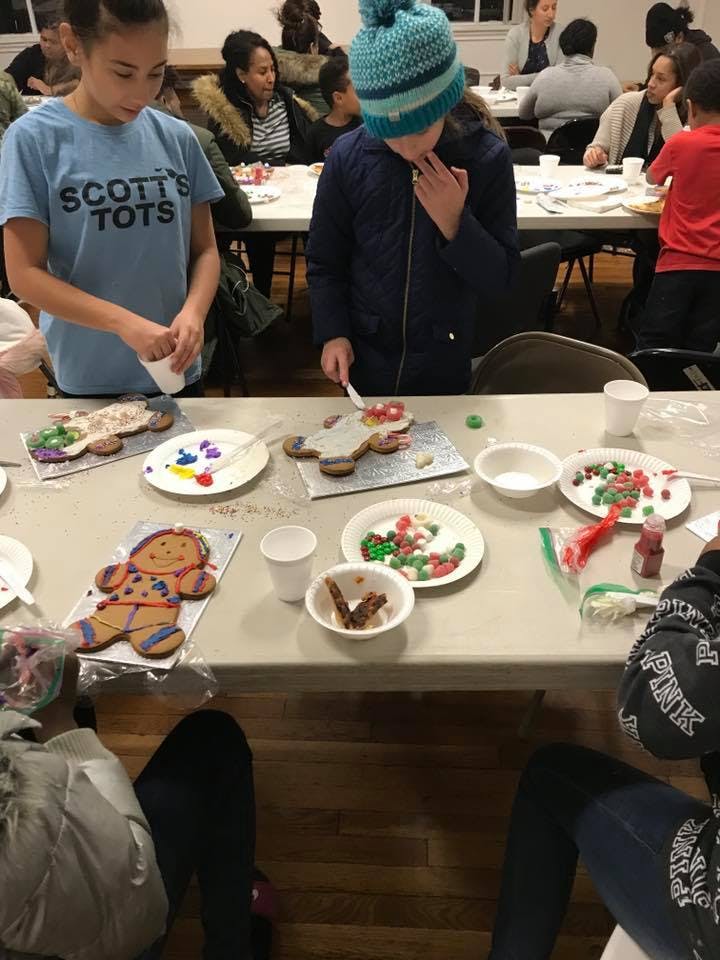 Two children decorating gingerbread cookies at a table
