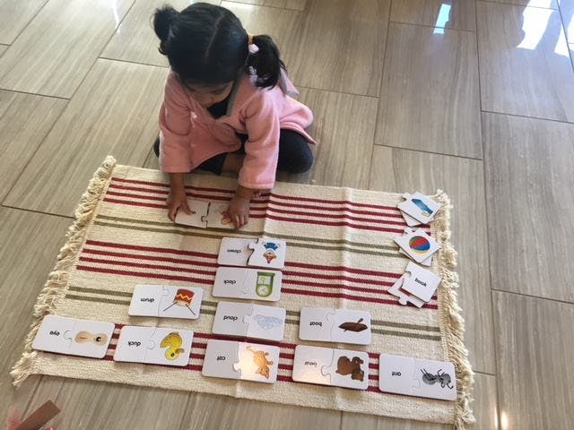 Child playing with matching cards on a striped rug