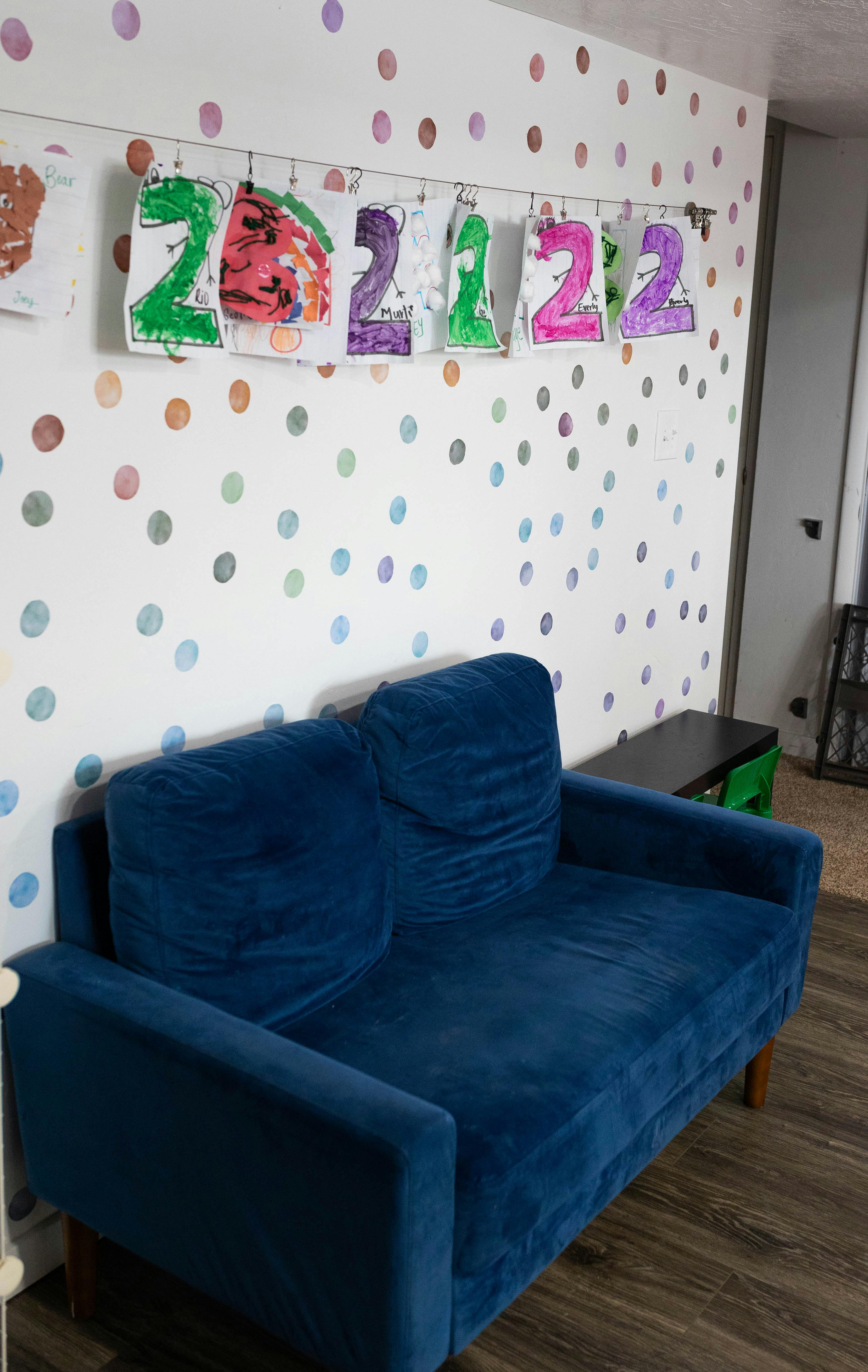 Blue sofa against a white wall with colorful polka dots and paper numbers