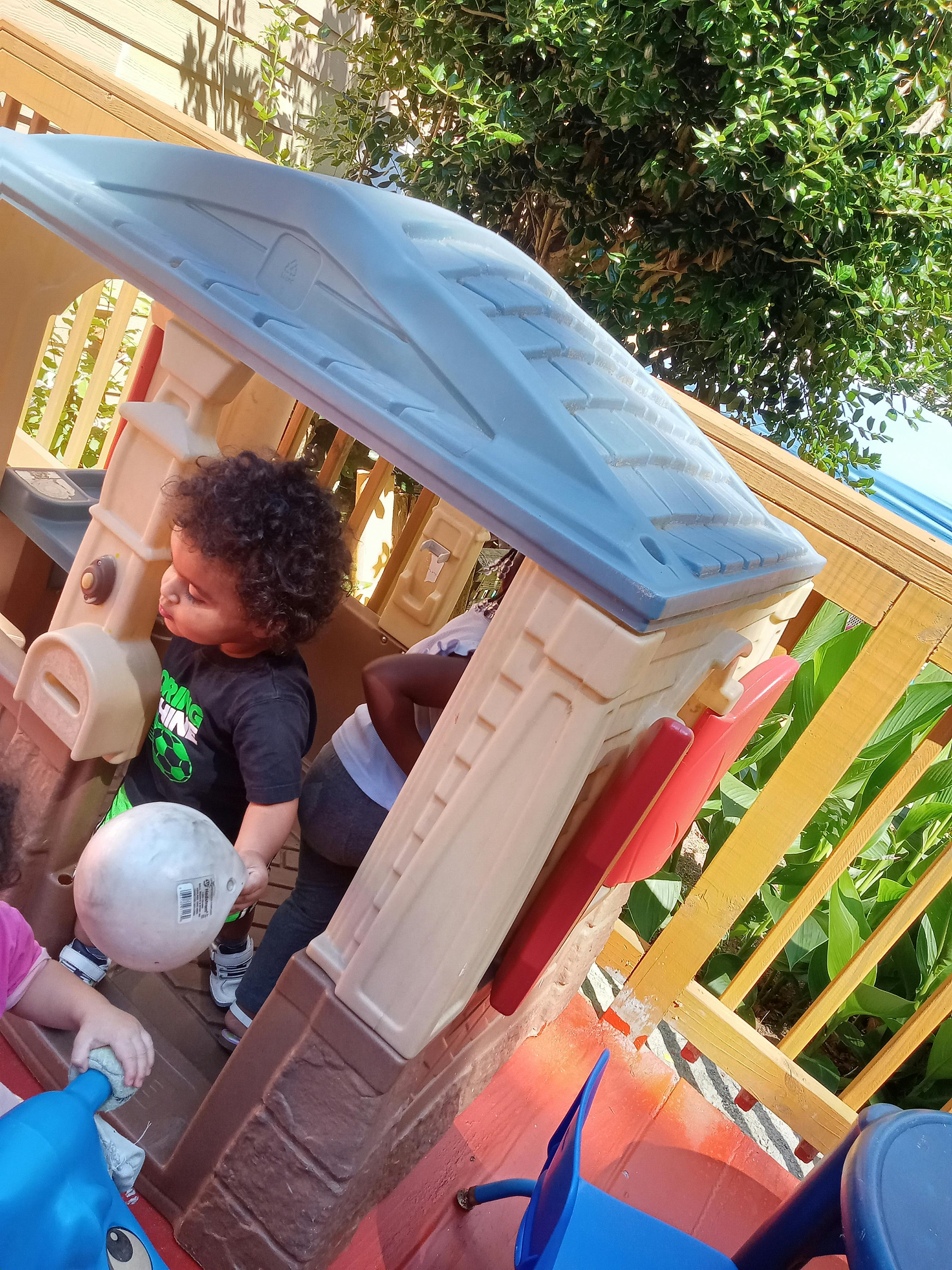 Child holding a ball in a playhouse