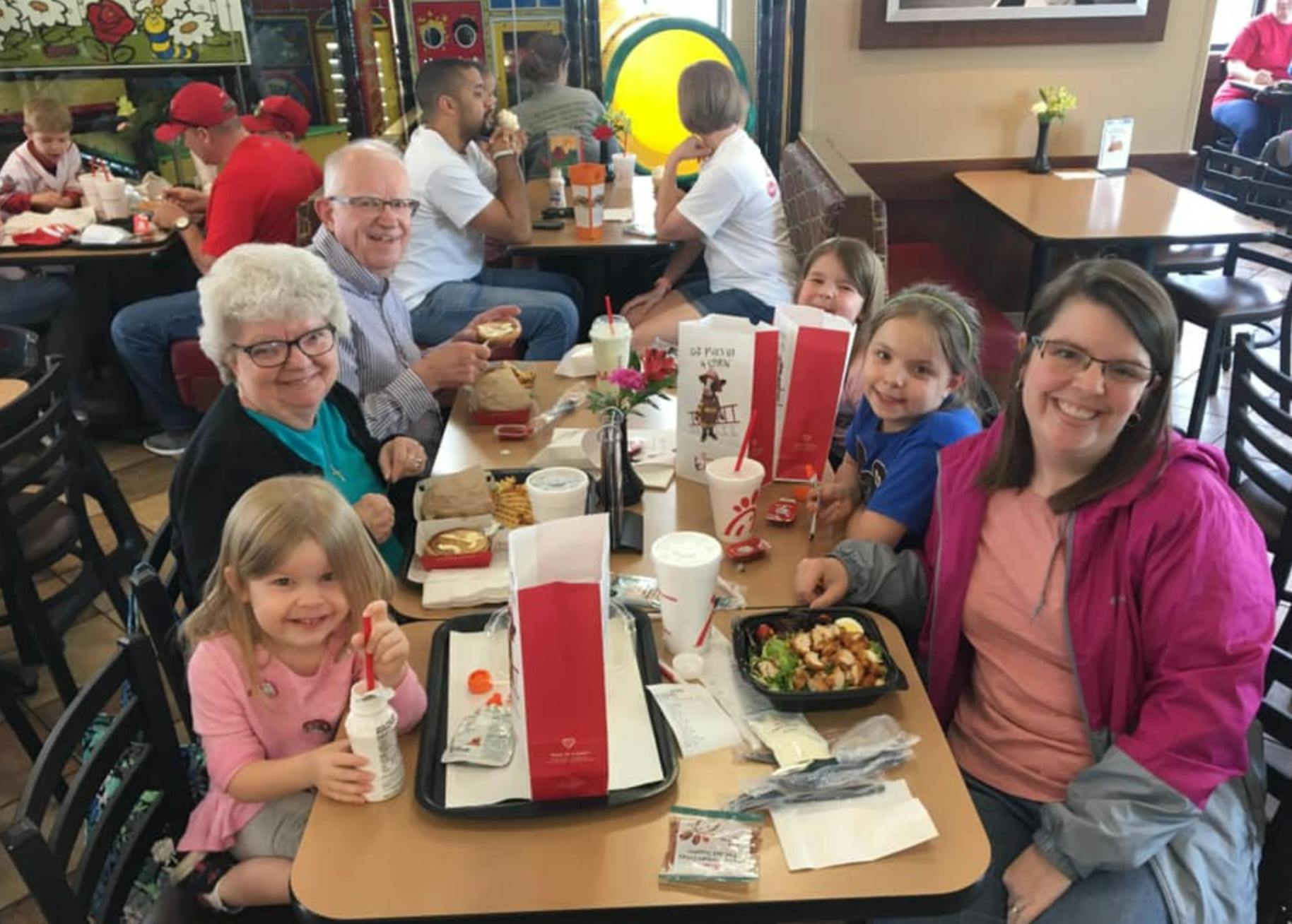 People and children sitting at tables in a restaurant