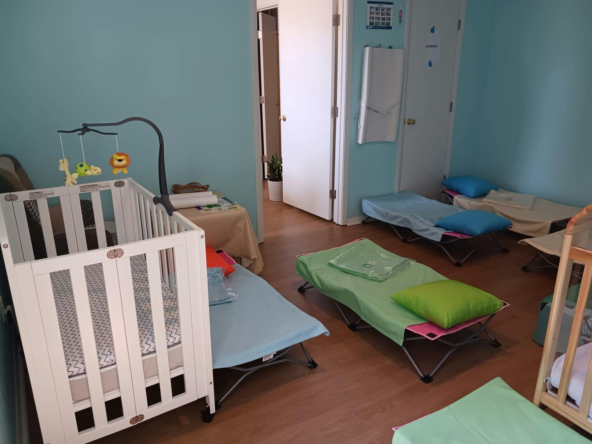 Nursery room with crib and several cots on the floor