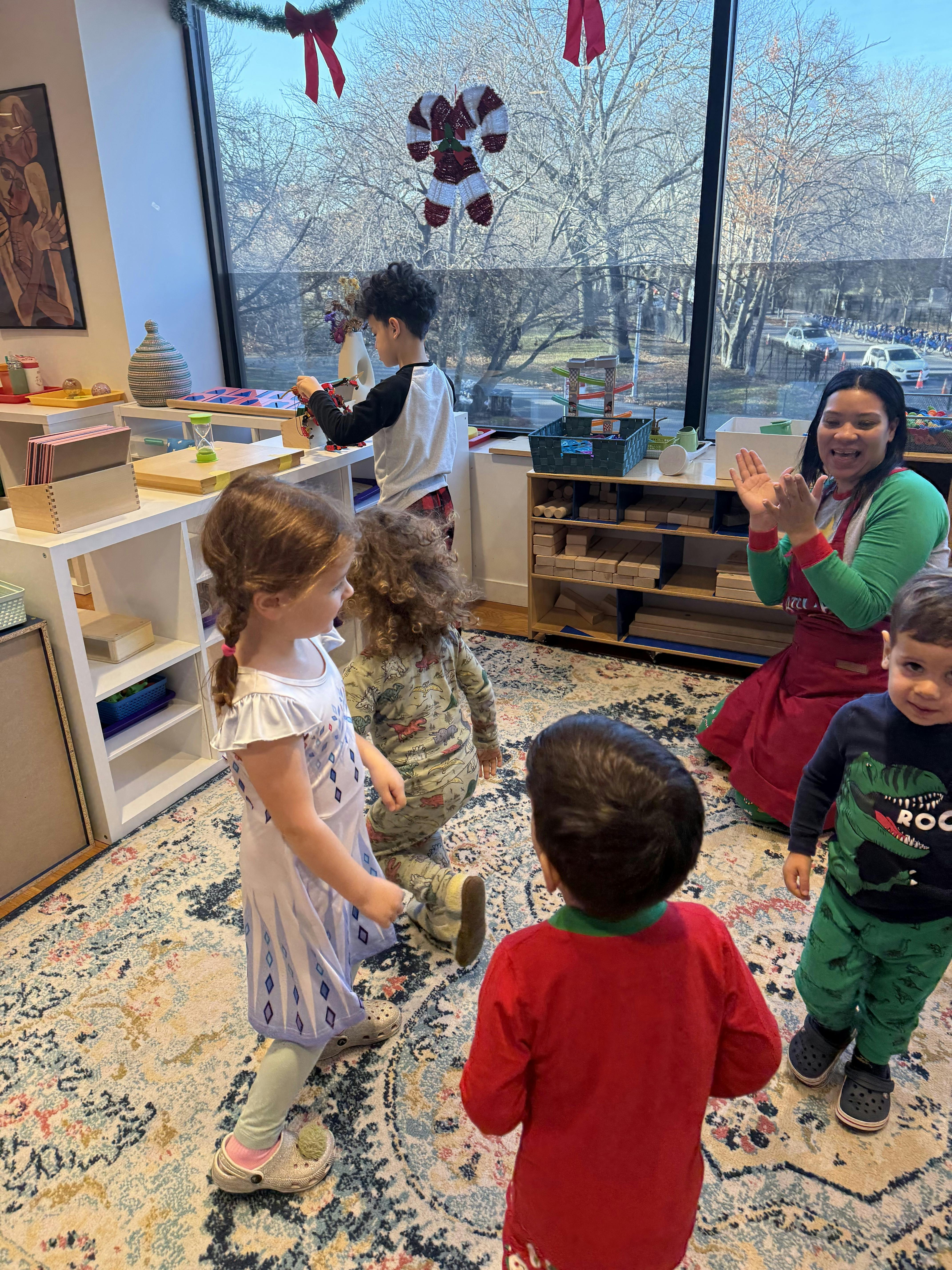 Adult clapping with children in a classroom