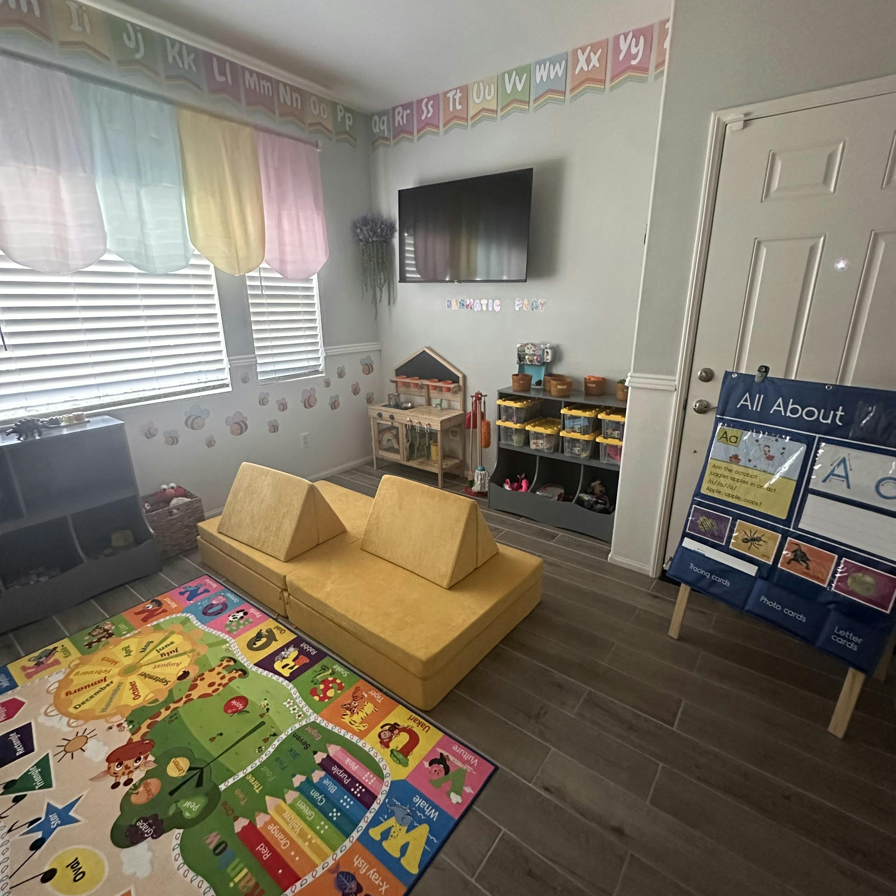 Colorful playroom with a play rug and modular yellow foam cushions