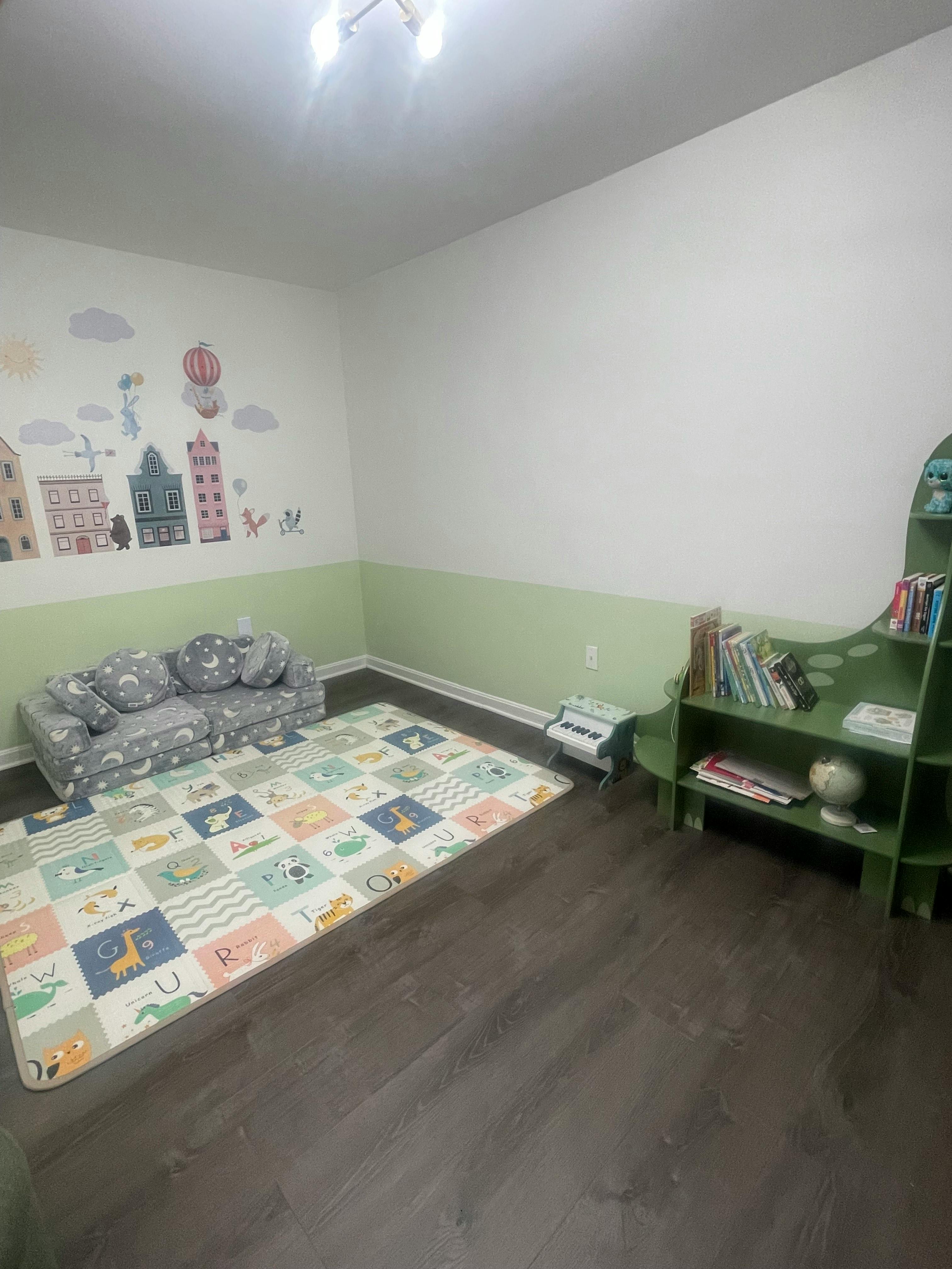 Children's play area with a sofa, rug, and bookshelf