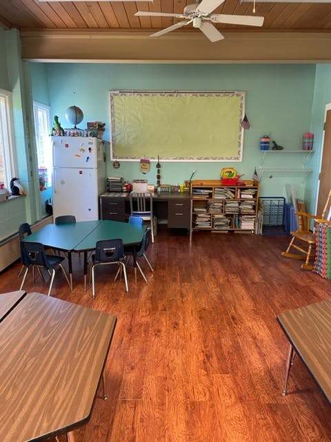 Classroom with tables, chairs, and a whiteboard