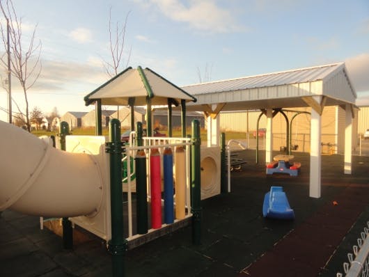 Playground with a slide, climbing structure, and covered picnic area